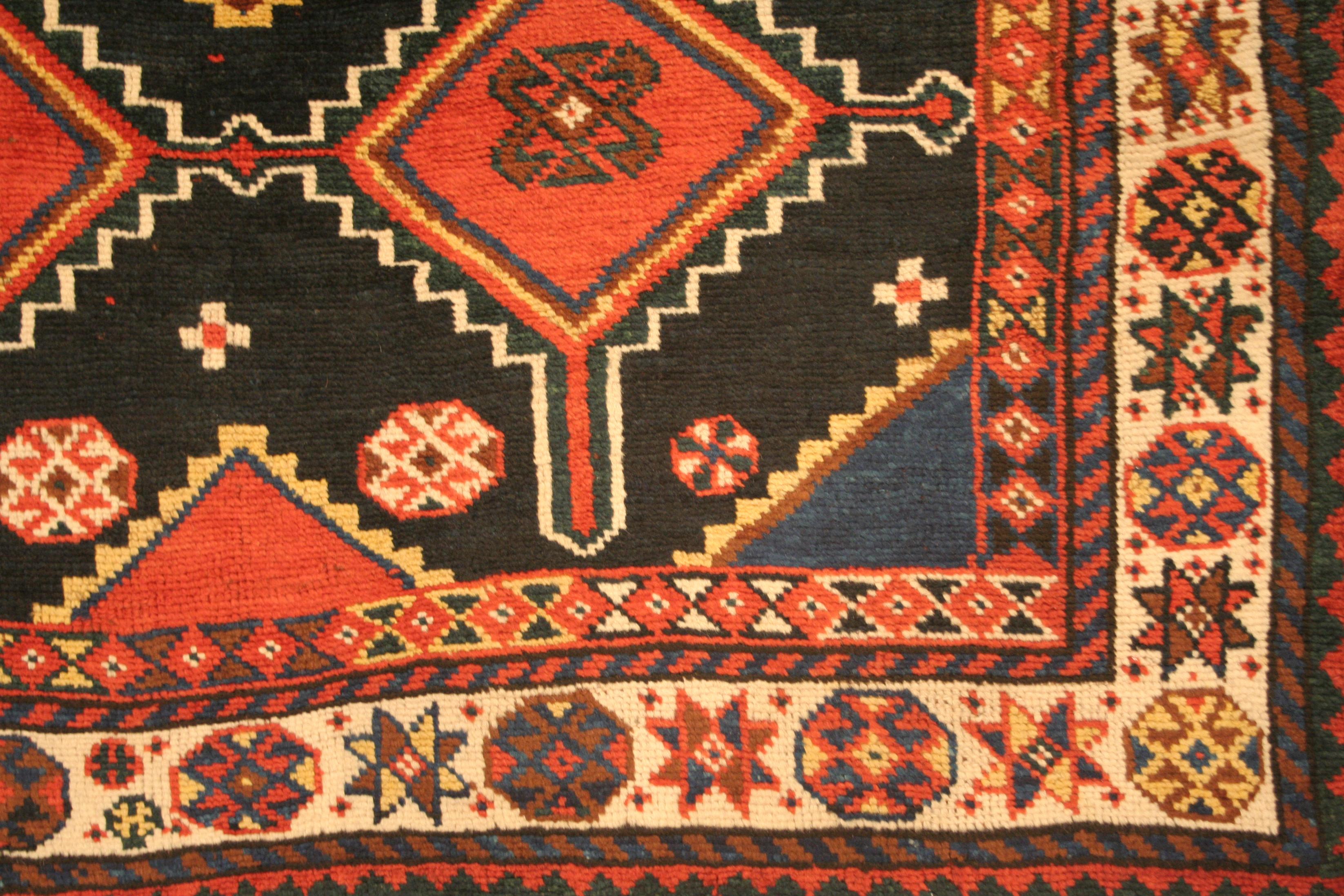 Ce magnifique tapis kurde ancien du sud du Caucase se distingue par sa gamme de teintures naturelles, qui comprend un riche fond bleu indigo, agrémenté de tonalités de blanc, de rouge, de jaune, d'abricot et de bleu clair semblables à des joyaux. Le