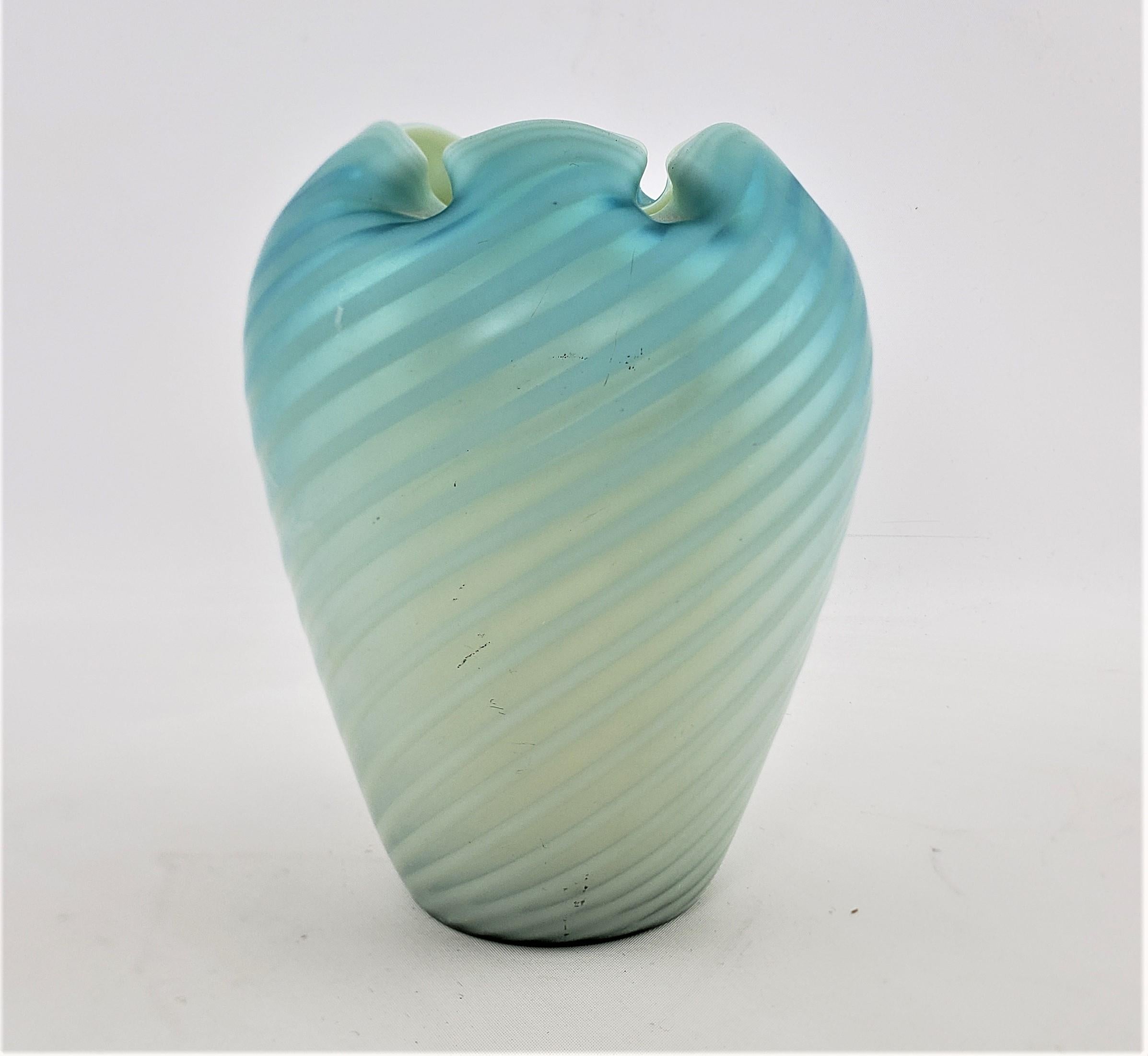 This antique and quite well executed art glass vase is unsigned, but presumed to have originated from the United States and dating to approximately 1880 and done in a period Victorian style. The vase is done in a deep blue with a strong iridescence