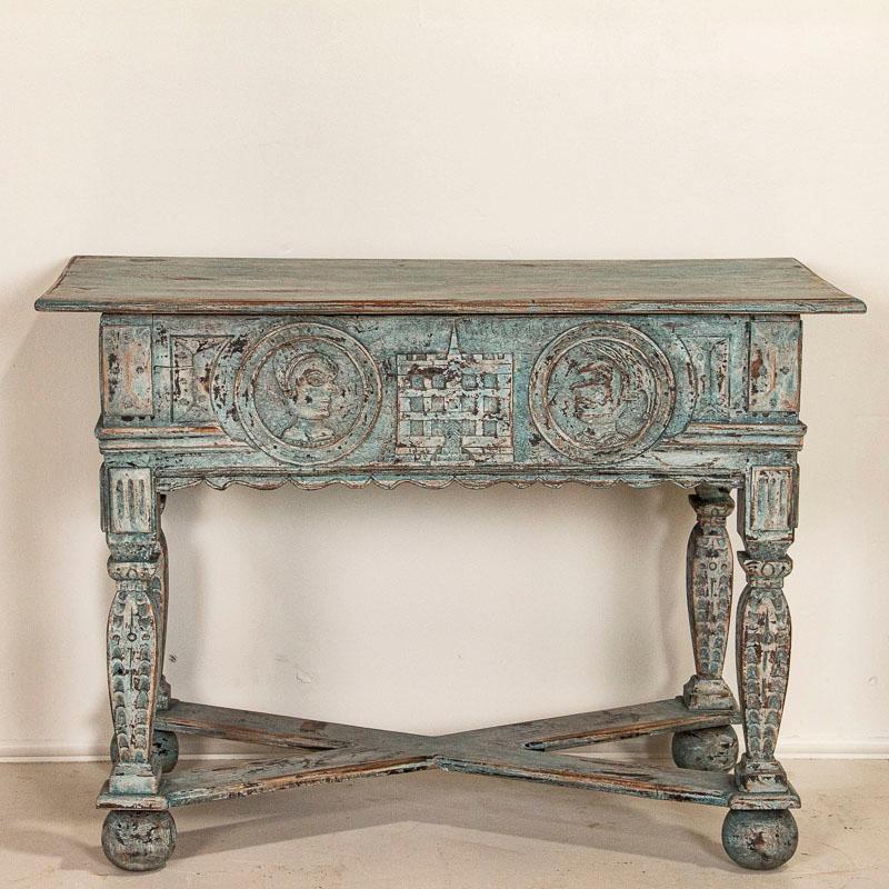 The enticing blue painted finish and intricate carving combine to captivate ones attention in this striking side table from France. The two carved faces appear to be portraits of a nobleman(on the right) and his wife (on the left), while intricate