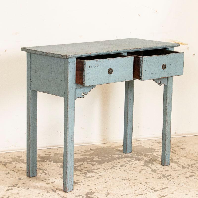 This delightful sideboard is made even more charming by its small size, allowing it to be used in a variety of spaces. The soft eggshell blue paint is gently distressed all over, adding grace to its age. This small blue console is part of our