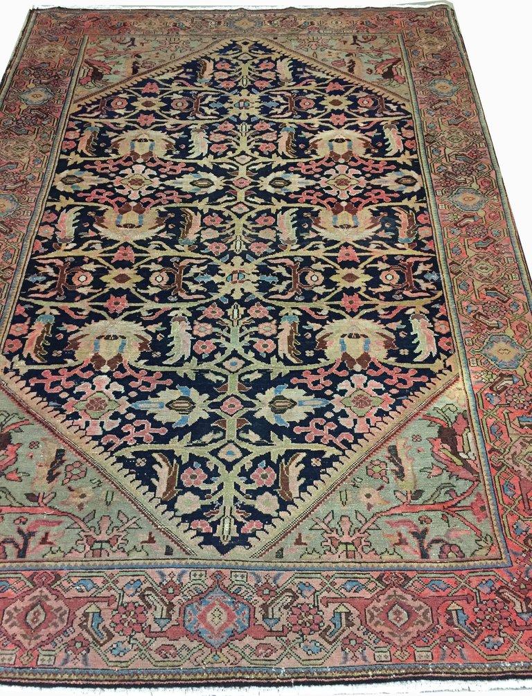 4'6 x 7'7. Preciosa alfombra sarouk de Persia, hacia 1900. El fondo azul marino tiene diseños florales y enredaderas maravillosamente detallados que muestran la verdadera artesanía del tejido fino en su máxima expresión. Los bordes suaves y las