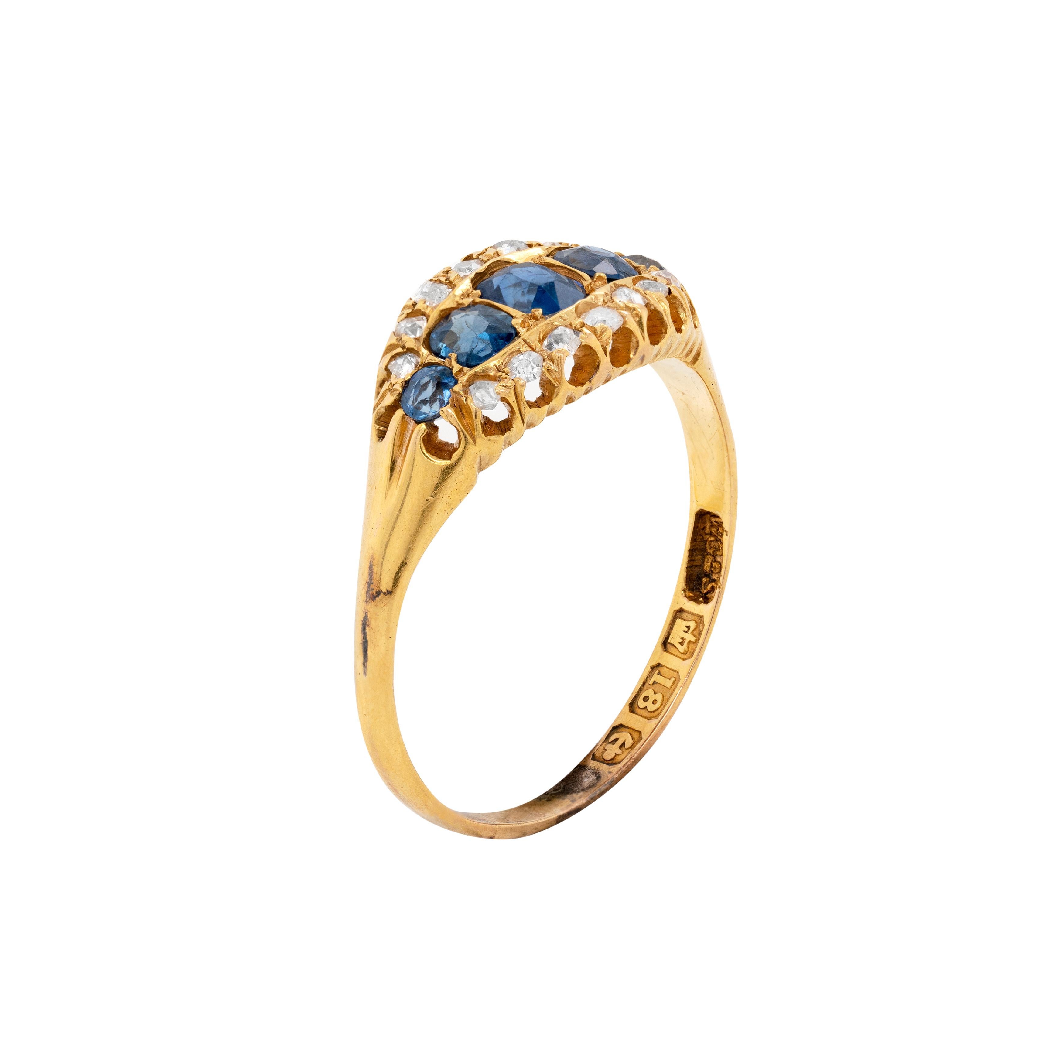 This original 18 carat yellow gold antique ring, dating back to circa 1890's, features a meticulously handcrafted fluted gallery that exudes great finesse and Late Victorian flair indicative of its era. The piece is horizontally set with 5 well
