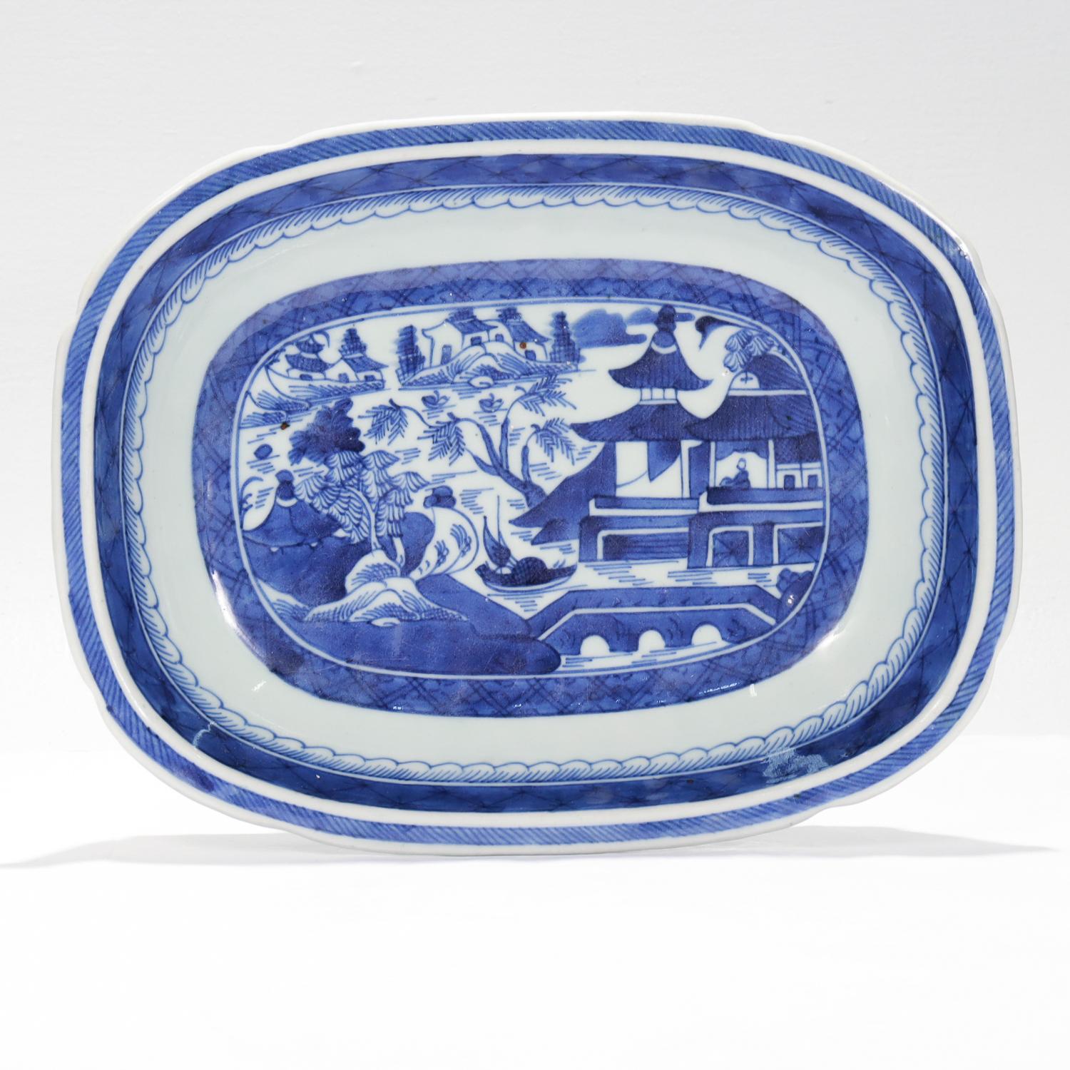 A fine antique Chinese export porcelain open vegetable bowl or dish.

In the Canton pattern.

Decorated in underglaze blue depicting a mountainous Chinese village to the top of the lid and the long sides of the body. The background has houses,