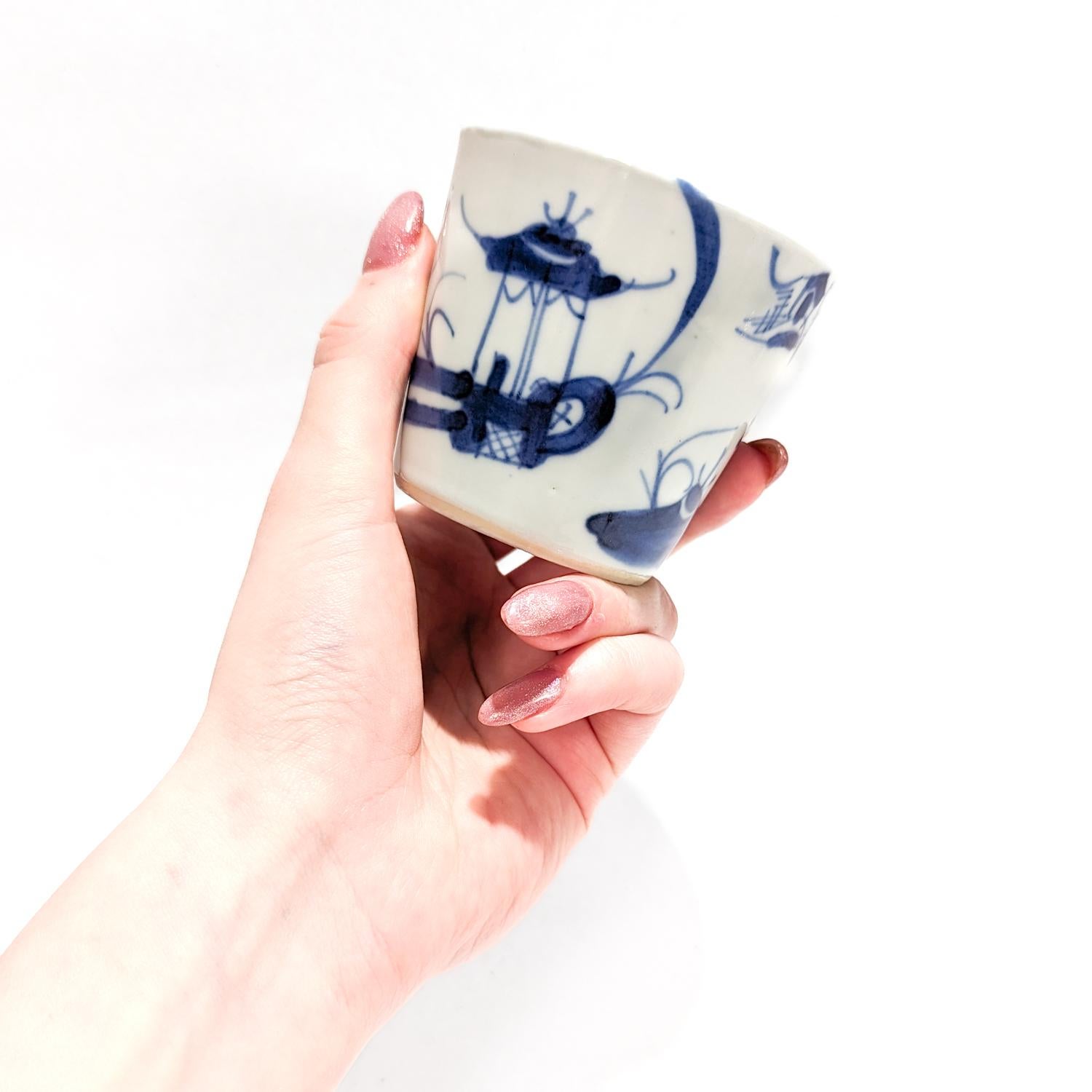 A fine Chinese export porcelain cup.

In the Canton pattern. 

With a white ground decorated in underglaze blue.

The exterior of the cup depicts Chinese buildings and plants. 

The interior of the cup with a floral spray to the center and a blue