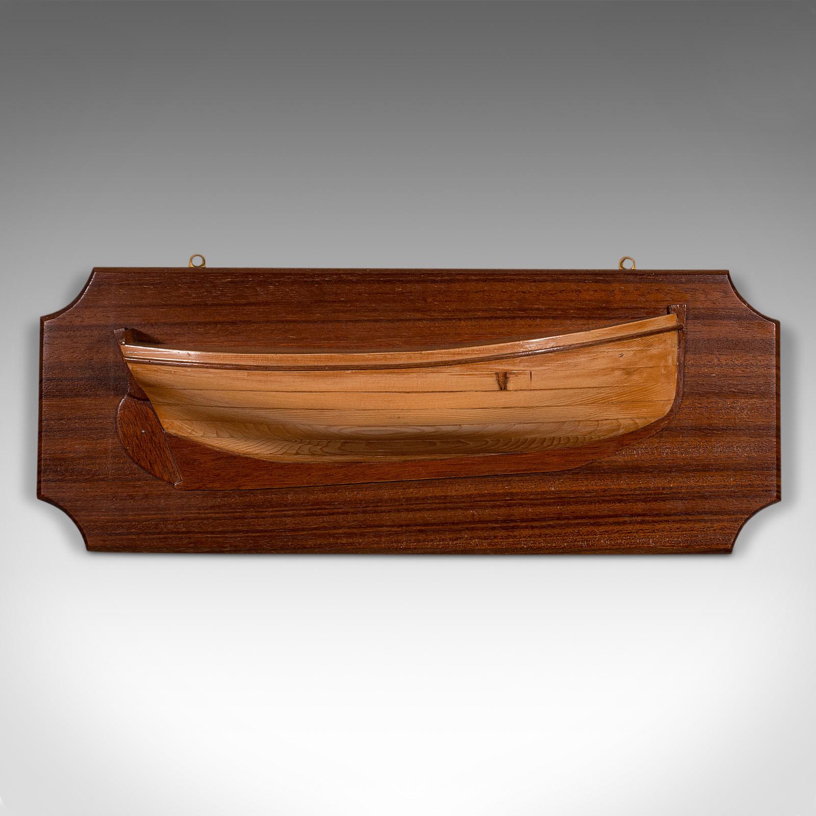This is an antique boat's half hull plaque. An English, mahogany and pitch pine decorative maritime model, dating to the Edwardian period, circa 1910.

Graced with beautiful figuring and craftsmanship
Displays a desirable aged patina and in good