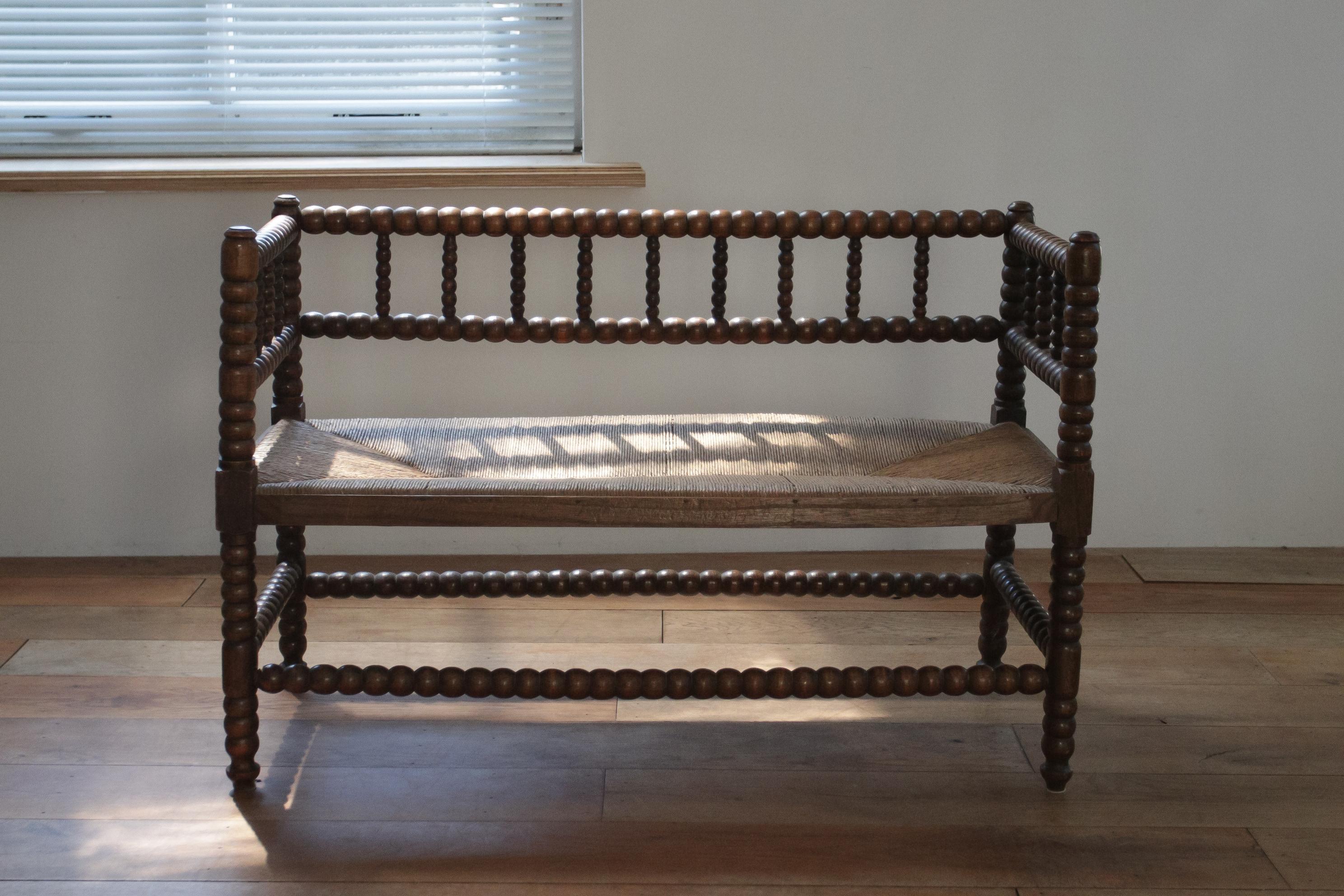Presenting our Antique Bobbin Bench, a classic piece from the 19th century, crafted with the finest attention to detail. Originating from England, this bench showcases the traditional woodworking technique of bobbin turning, renowned for its