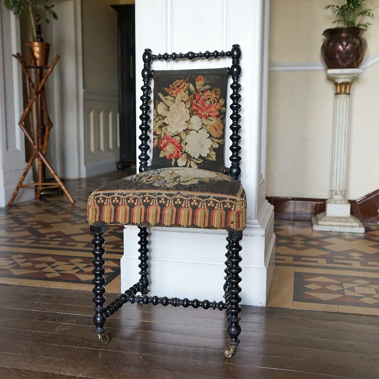 Antique Upholstered occasional chair

Profusely bobbin turned and ebonised on all exposed wood including back legs and stretchers.

Antique needlepoint tapestry upholstery depicting floral sprays.

Raised on original brass castors.

Unsure