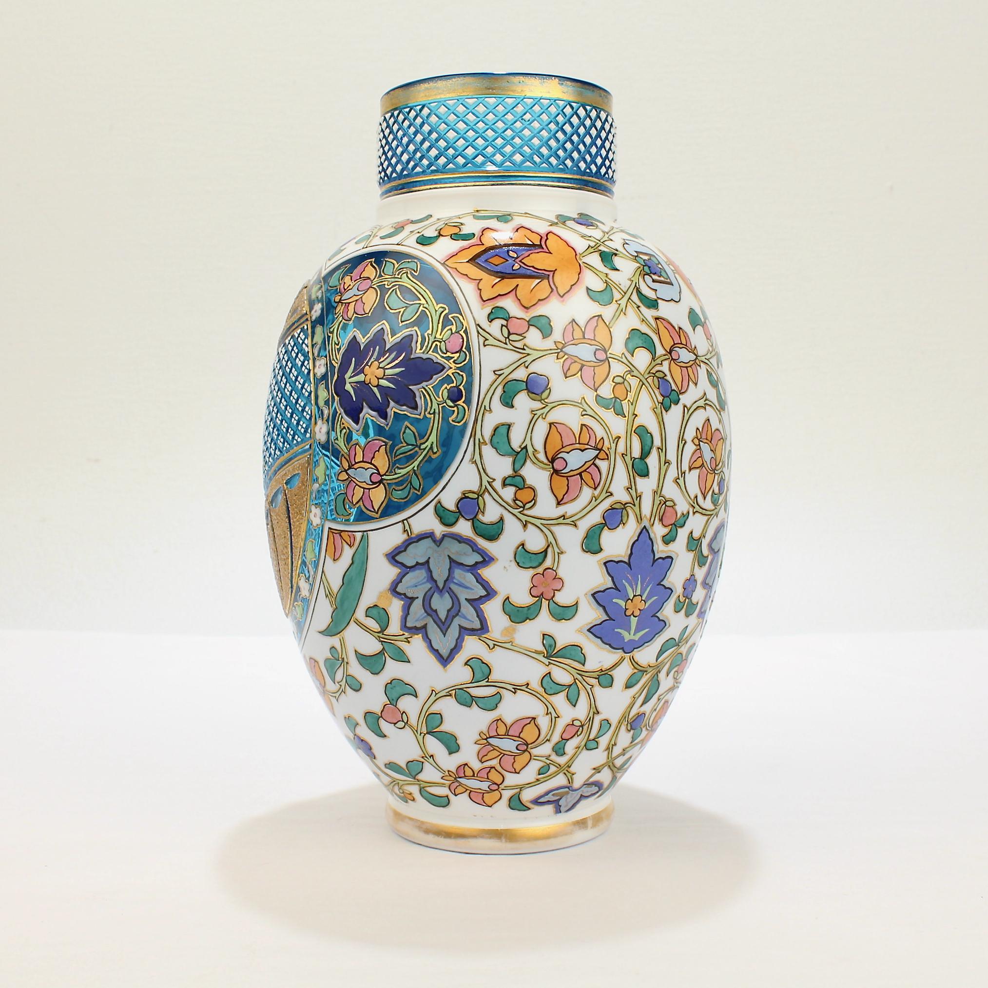 A very fine Bohemian aesthetic period enameled and cut-to-clear art glass vase.

In two colors with a white cased top layer cut to reveal a blue ground in the style of the Moser or Josephinenhütte factories.

With diamond cuts, enamel stylized