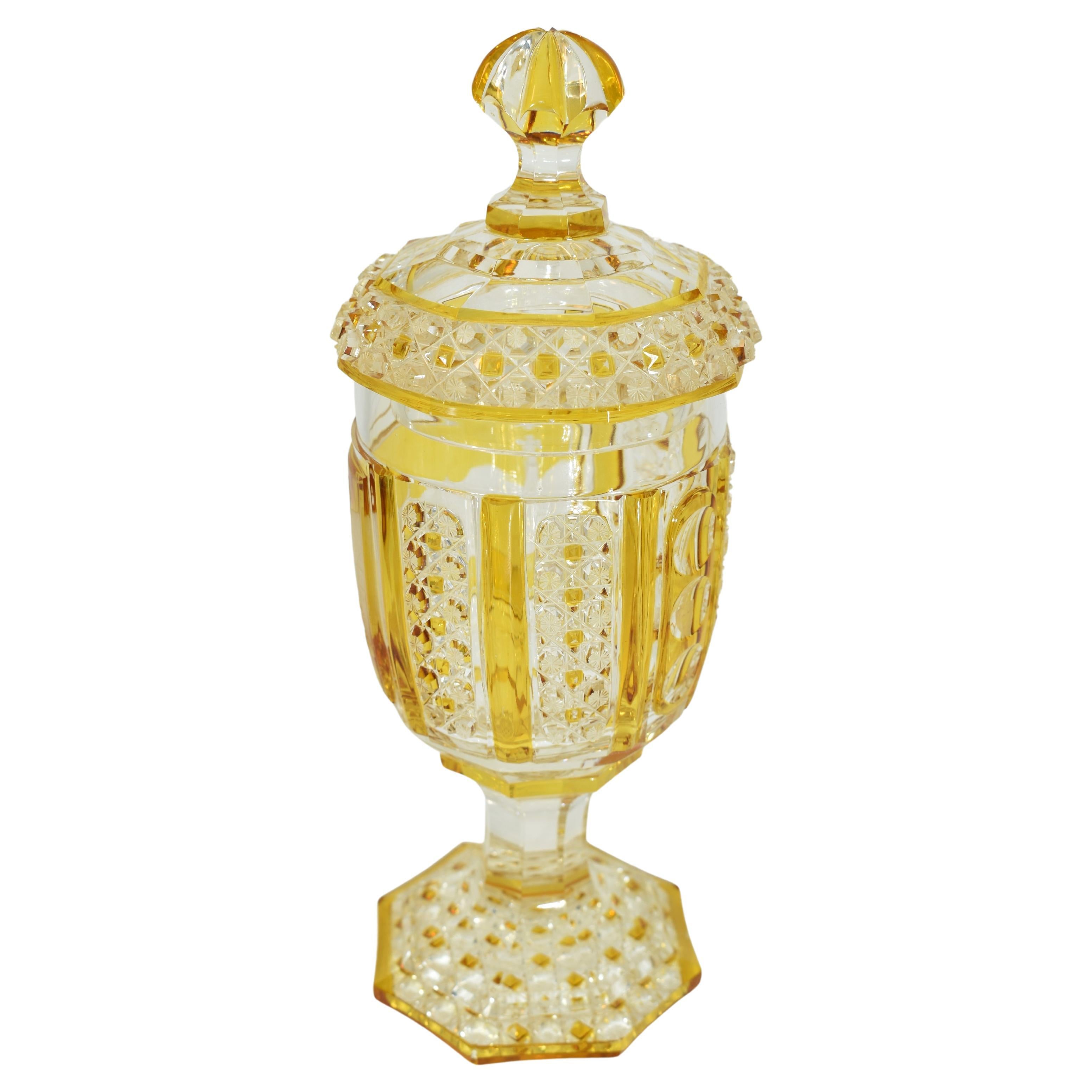 19th century amber stained goblet, the cup-shaped body with a raised circular panel, engraved with what seems to be a village scene with people standing among hills and several buildings and an inscription 