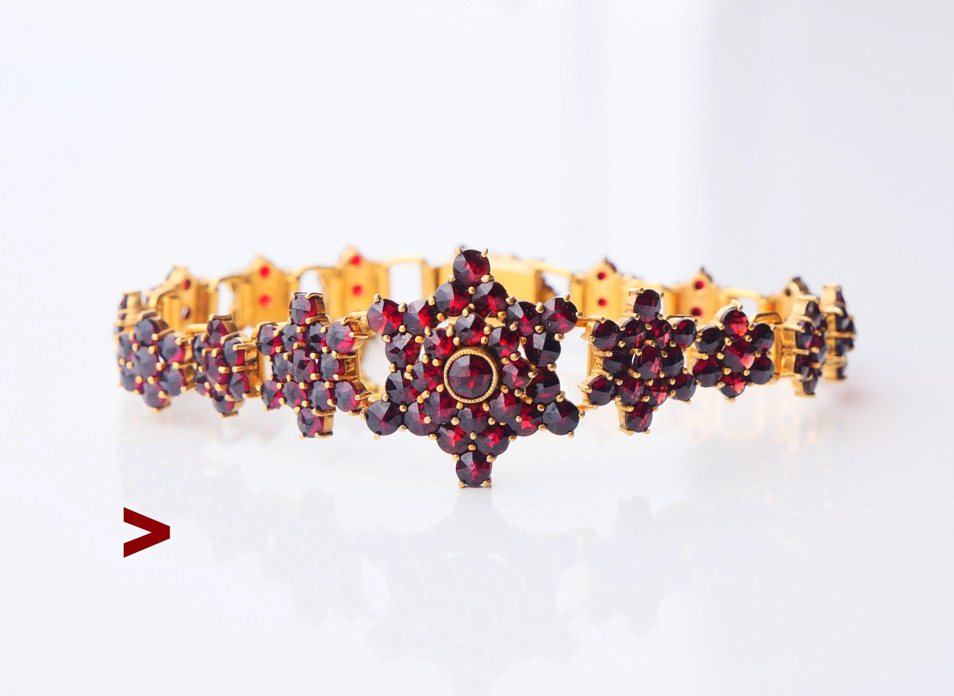 Bohemian  flexible bracelet with deep red rose cut garnets claw set in florets. Handmade in Central Europe/Bohemia.No Marks. Composed of 17 main parts.

Metal is high grade Silver filled with a thick and wear resistant layer of  18K Yellow Gold.