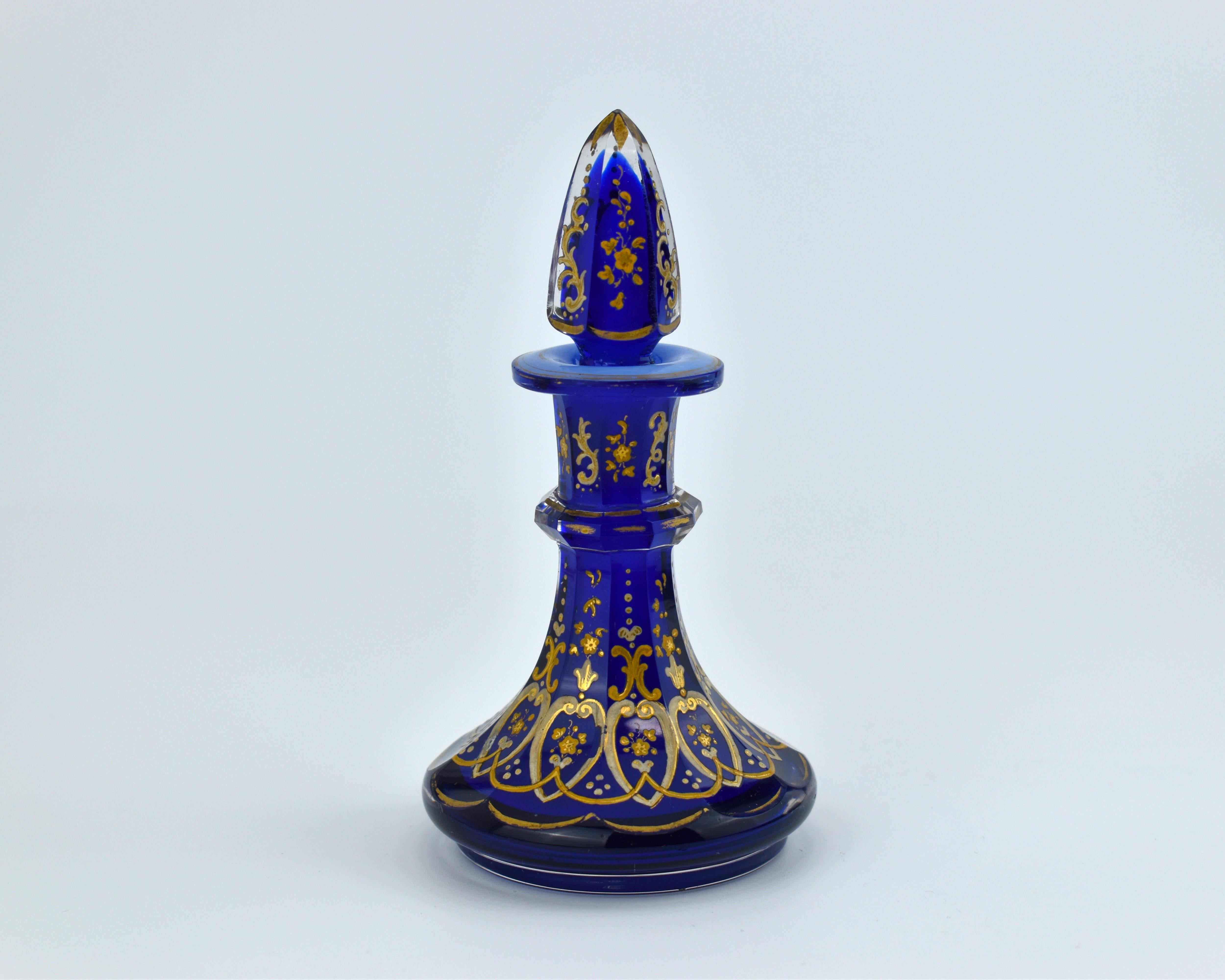 Cristal azul cobalto de la manufactura vidriera de Bohemia del siglo XIX

el cuerpo está cortado en 10 paneles laterales y profusamente esmaltado con flores y volutas, más esmaltado en el cuello y el tapón, el tapón está cortado en 6 lados y
