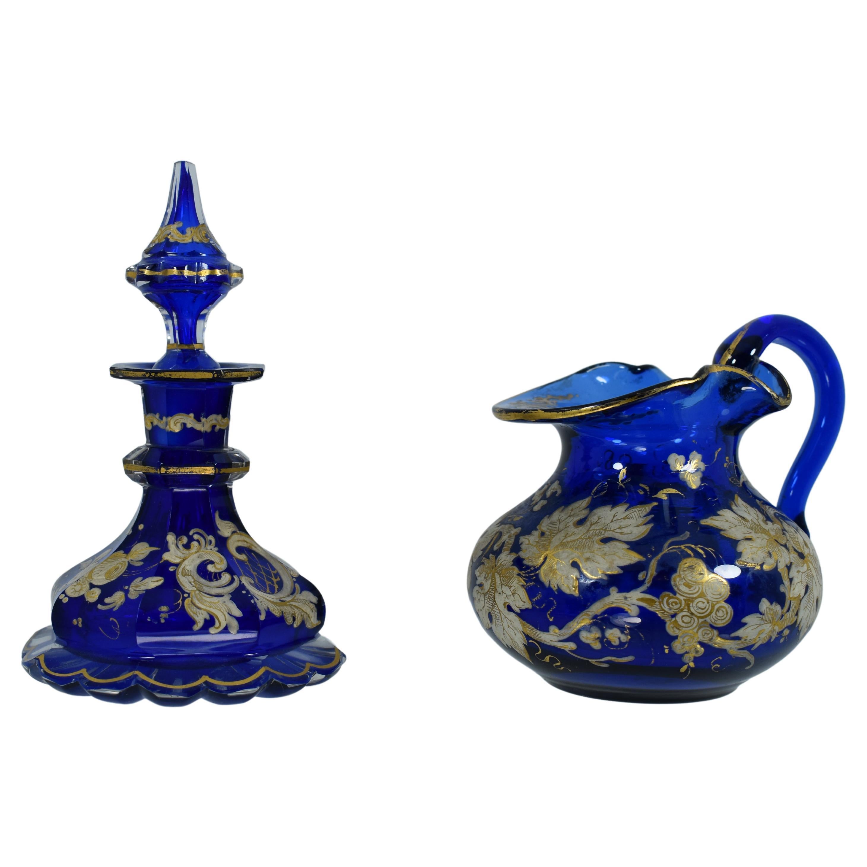 A perfume bottle and a milk jug in cobalt blue crystal from the Bohemian glass manufacture of the 19th century.
Profuse enamelled with flowers, vines and scrollworks.
Bohemia, Circa 1880
Bottle stands 12.5 cm high.