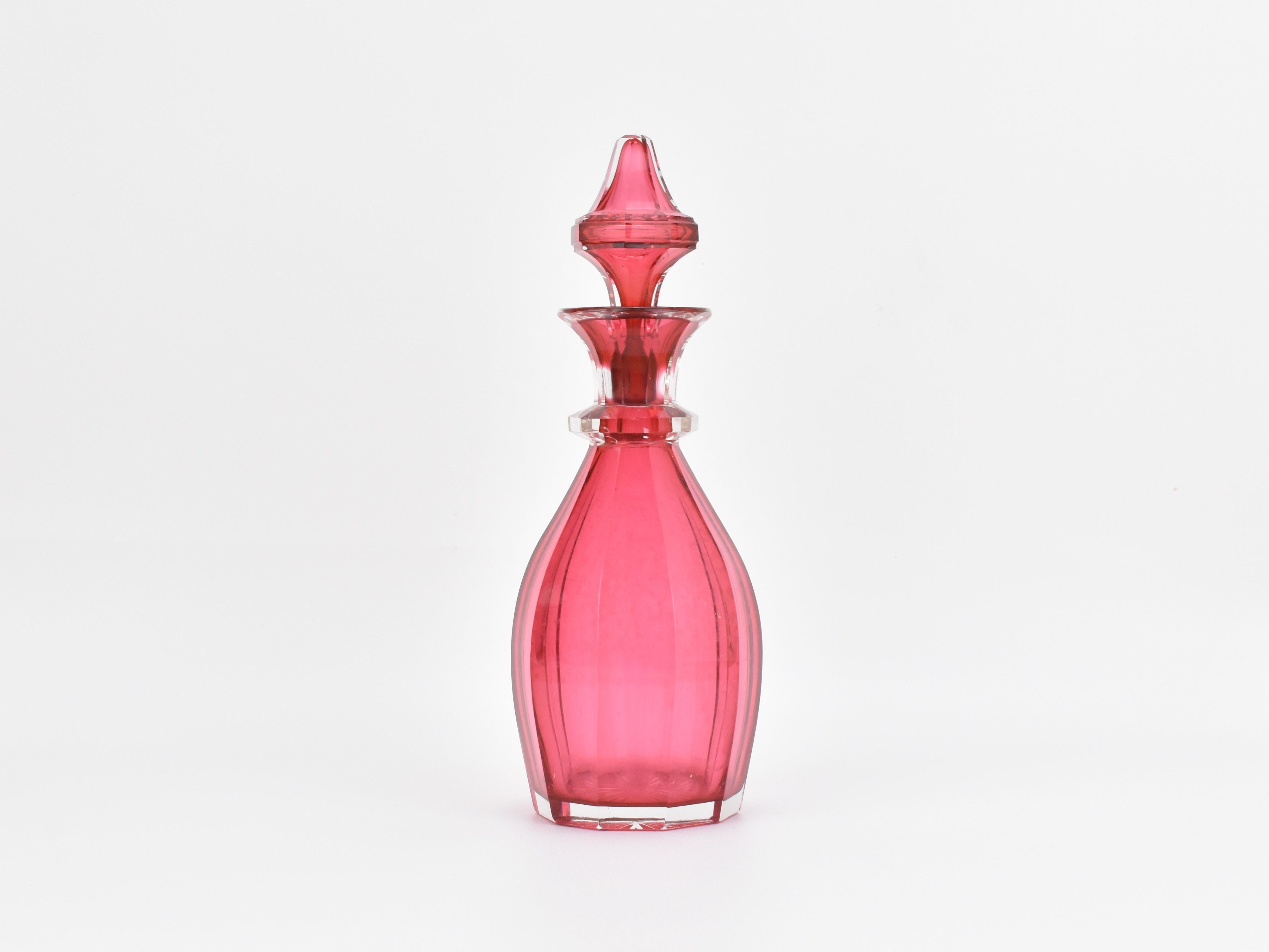 Dieser antike Parfümflakon aus böhmischem Preiselbeerglas, der der berühmten Glashütte Moser zugeschrieben wird, stammt aus der Mitte des 19. Jahrhunderts, etwa aus dem Jahr 1860. Der Flaschenkorpus ist elegant in mehrere Seitenteile geschliffen und