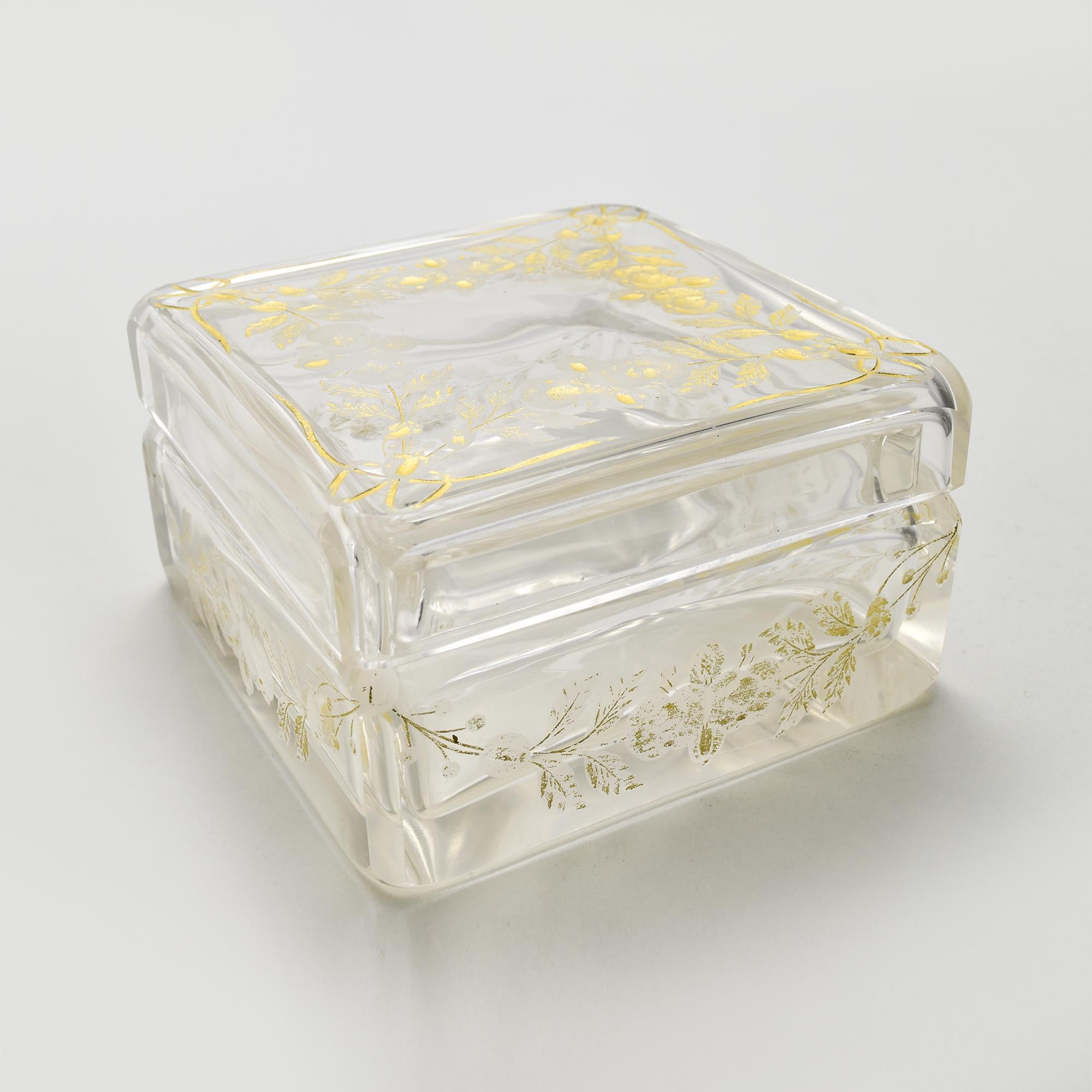 Esta impresionante caja antigua de cristal de Bohemia se atribuye a Ludwig Moser, el renombrado vidriero de Karlsbad, célebre por sus exquisitos diseños y su inigualable artesanía. La pieza presenta motivos florales meticulosamente grabados y