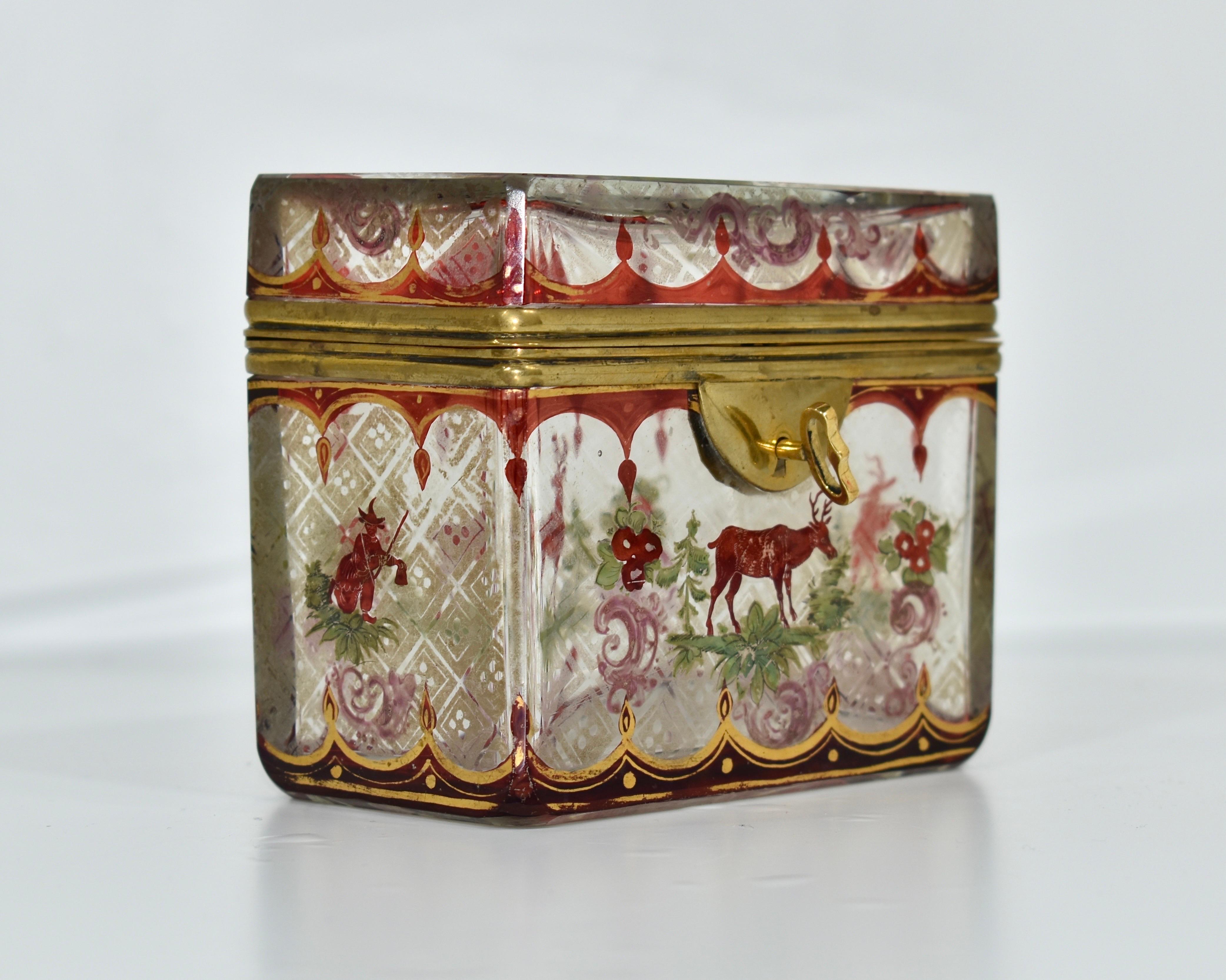 Fine Bohemian Clear and Ruby Red Glass Casket Jewelry Box with Hinged Bronze Mounts

Lid is Framed in Dore Bronze

Generously Decorated all Around with Gilded Enamel and Hunting Scenes

Original Key is Available

Bohemia, Moser, 19th century.