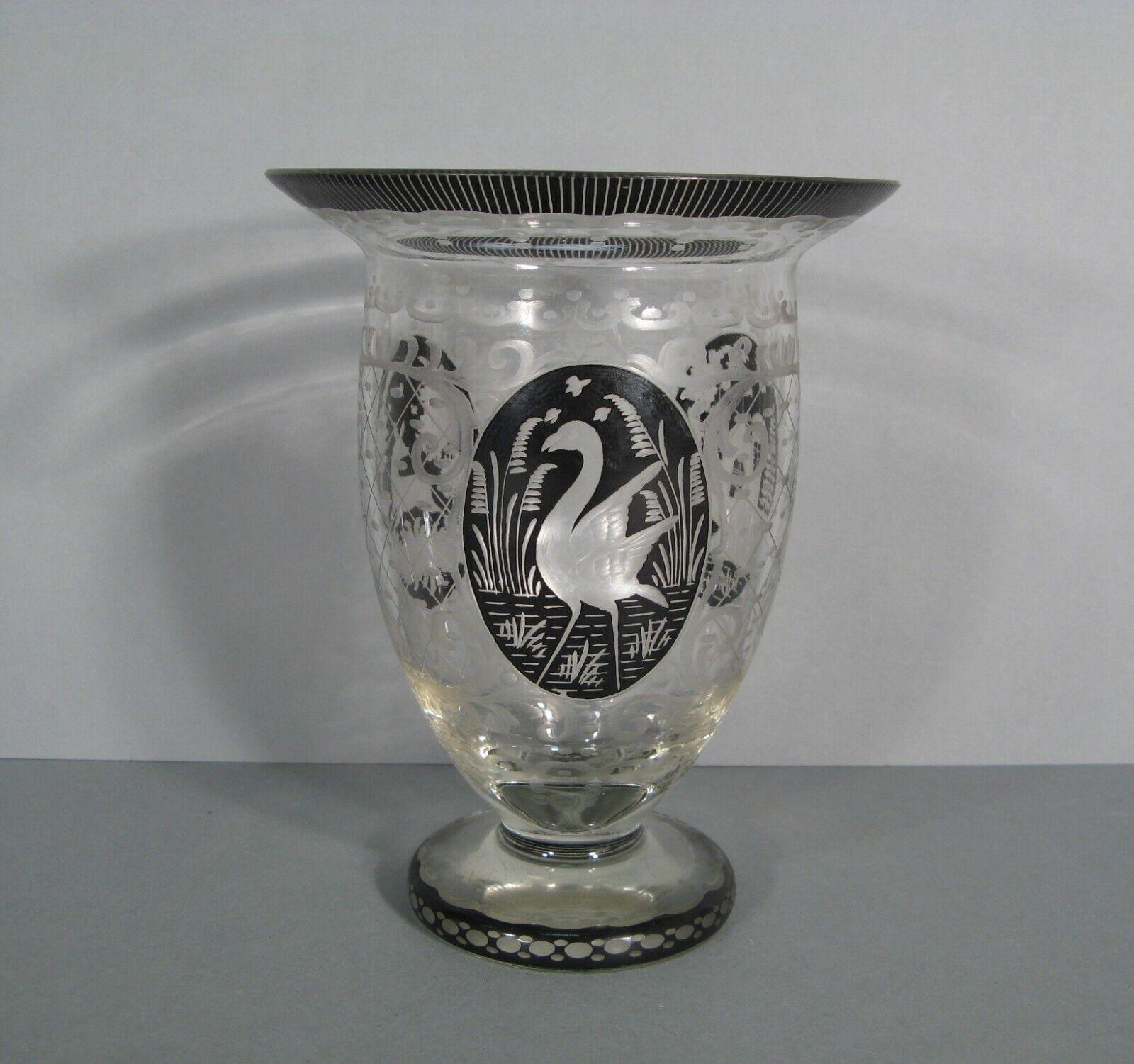 Questo splendido vaso antico, realizzato in cristallo acidato di Boemia, presenta intricati disegni di un castello, un cervo, un uccello trampoliere ed elementi stilizzati. Risalente agli inizi del XX secolo, questo pezzo è un bellissimo esempio di
