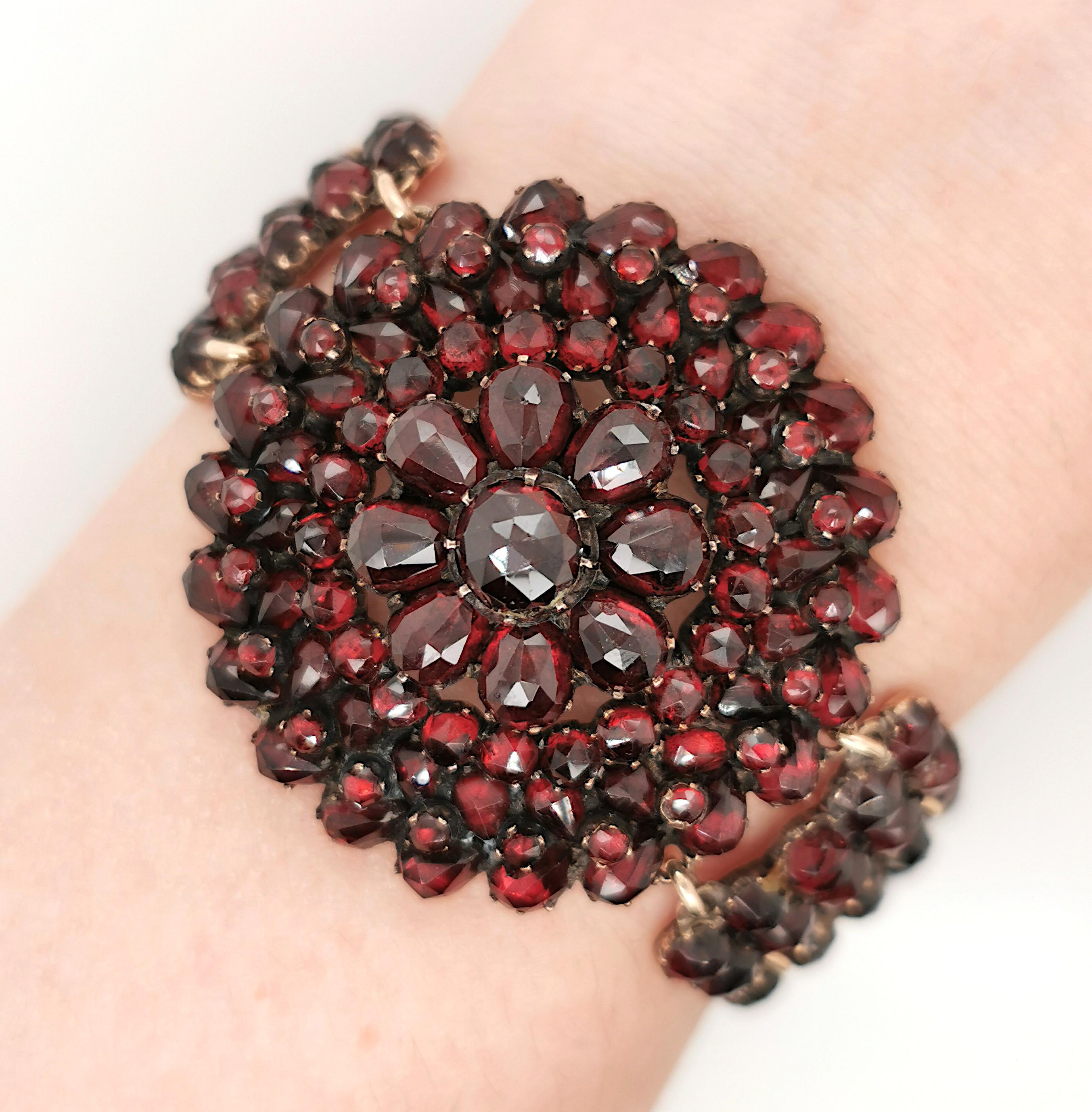 A Bohemian garnet bracelet, consisting of rose-cut garnets, with a central circular cluster of garnets graduating in size, the bracelet consisting of vertical bars, each set with two columns of garnets, linked together by jump rings, mounted in