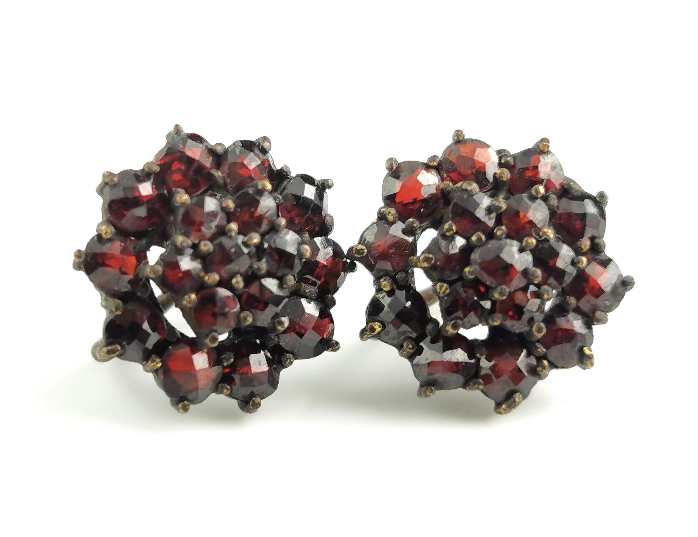 A beautiful pair of antique Bohemian garnet cluster earrings.

They are are screw back earrings in gilt metal c1920.

They feature graduating circular rows of rich red bohemian garnets in a cluster style.

Unmarked.

Condition:
Fair used condition