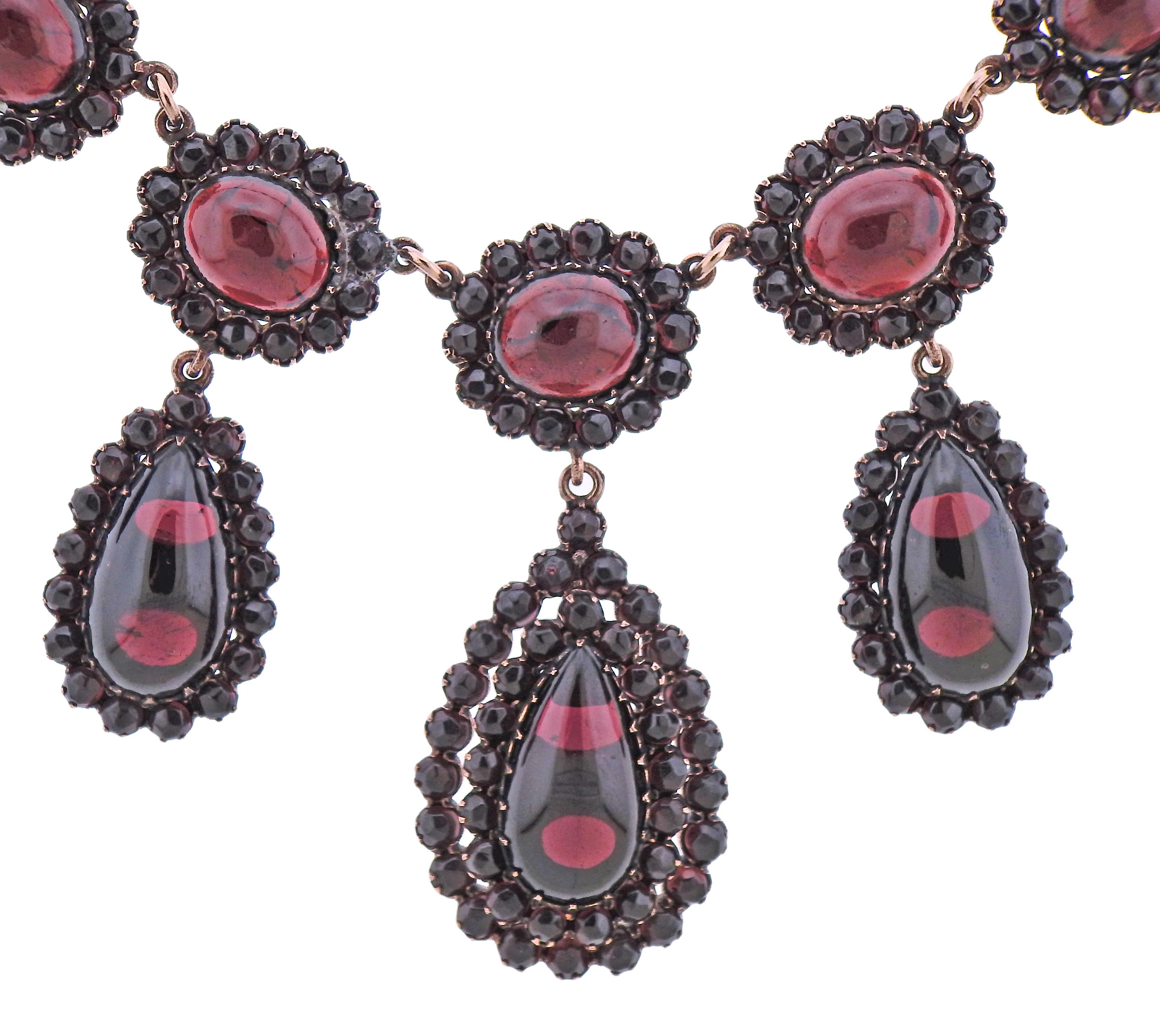Collier ancien en métal de base de couleur rose avec des grenats de Bohème (plusieurs pierres sont ébréchées). Le collier mesure 16,5