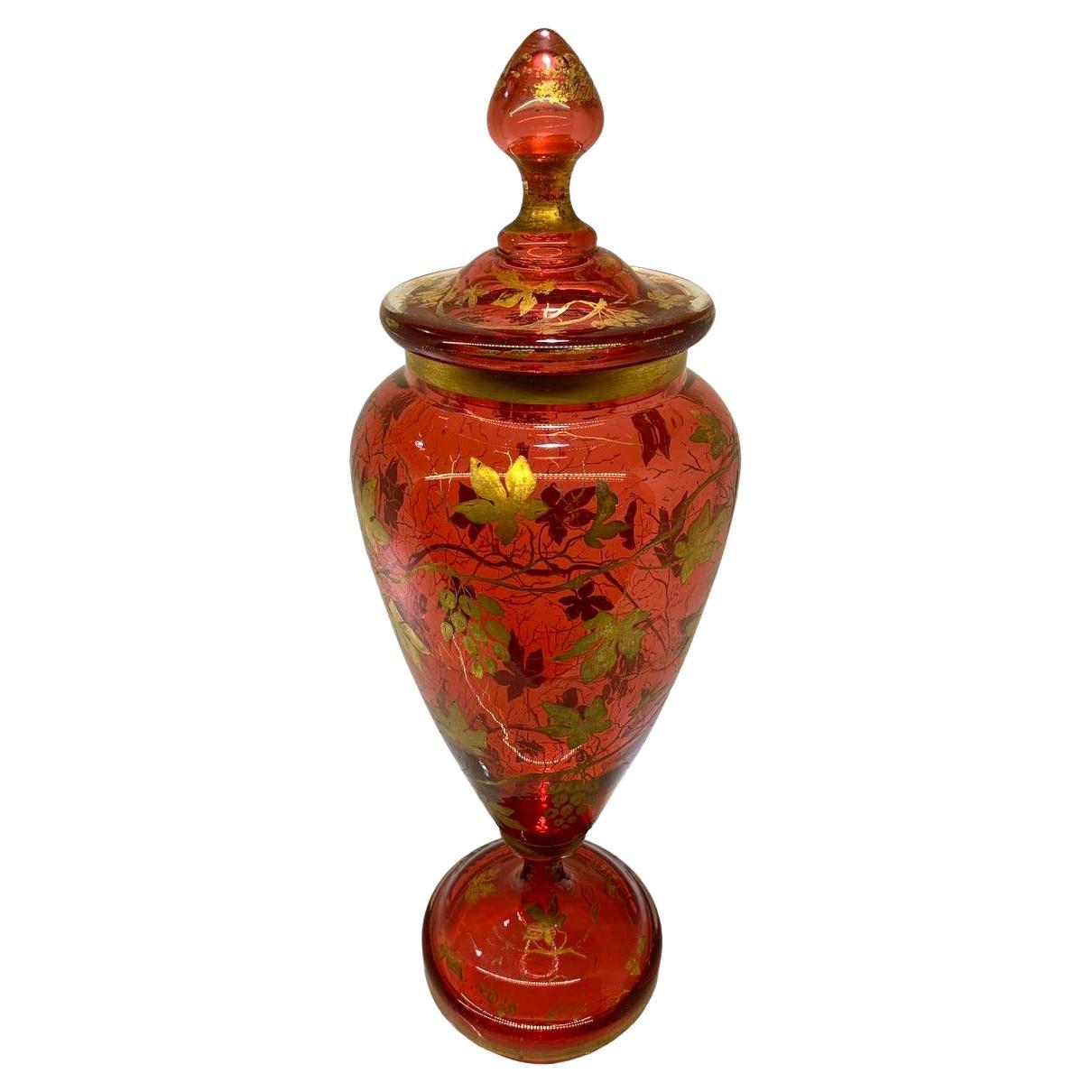 Cranberry glass vase with lid
Rich Gold Enamel Decoration all around the circular body featuring Vines
Further Gilding highlights on the rim, base and lid
Bohemia, 19th Century.