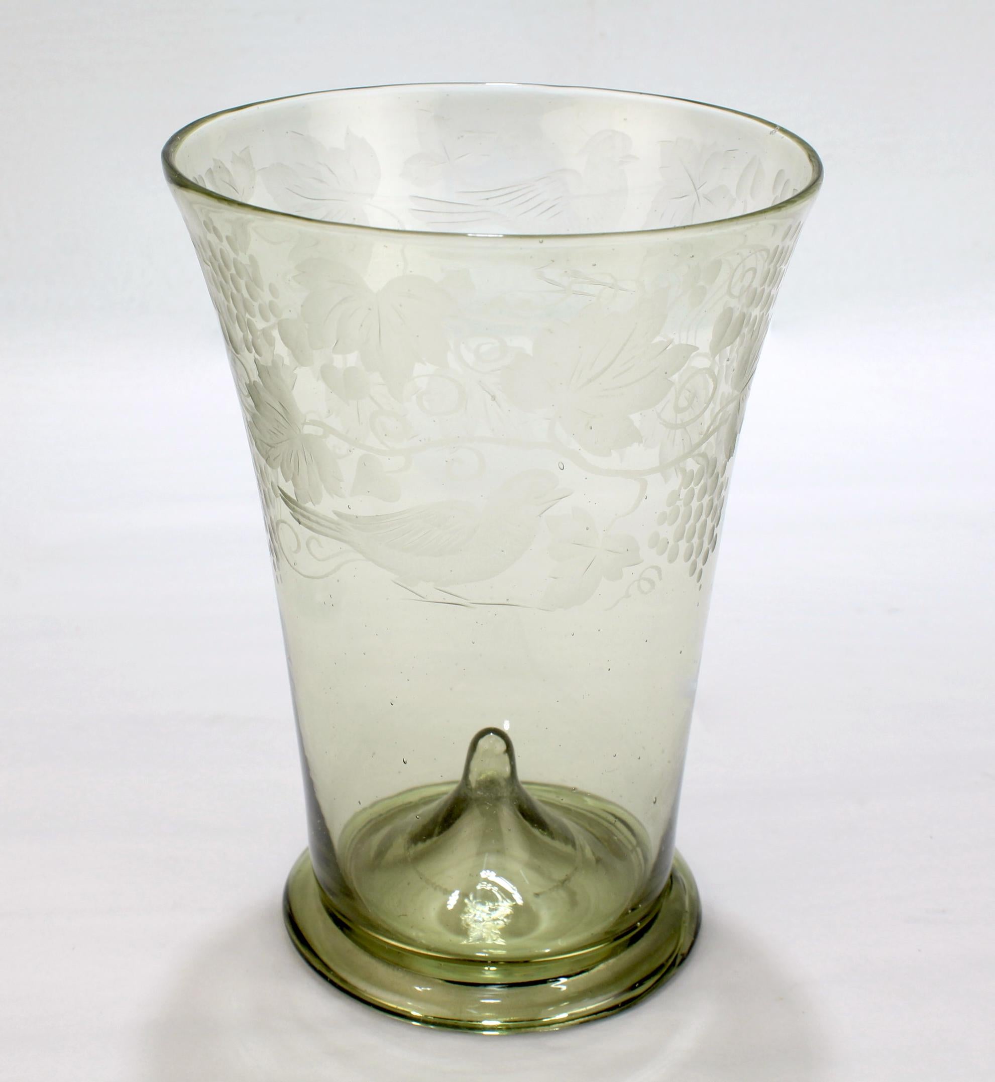 A fine antique Bohemian glass tumbler cup or mug.

The tumbler is a central European Historicism Period reproduction of a Middle Ages 'Waldglas Becher', having a flared lip, folded foot, and pushed up pontil mark. 

The circumference is engraved