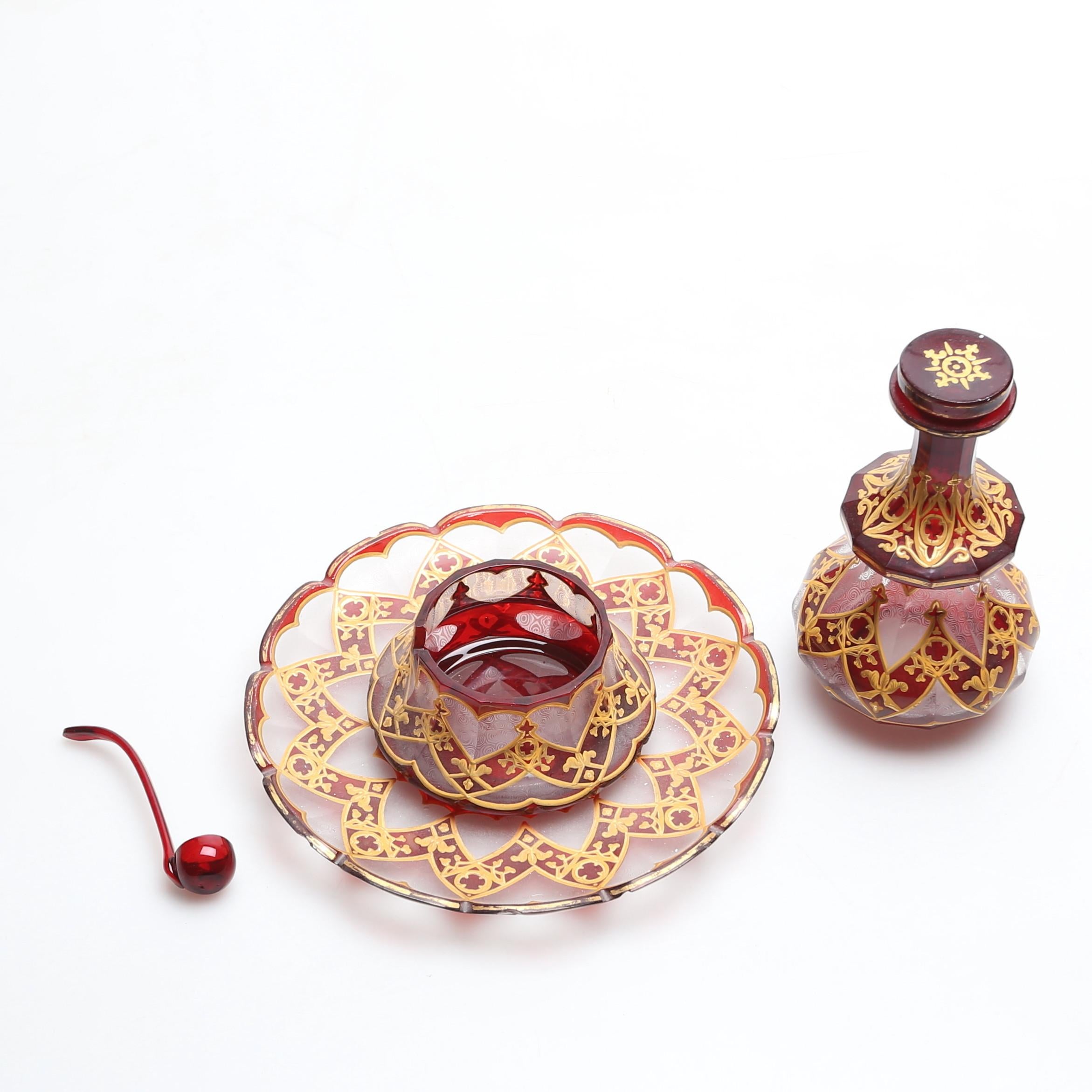 An exquisite bottle and stopper with matching plate, saucer and spoom

Ruby red crystal glass, decorated all around with multiple shapes and patterns

profusely decorated all around with gilded enamel

the plate with gilded scalloped rim

Bohemia,