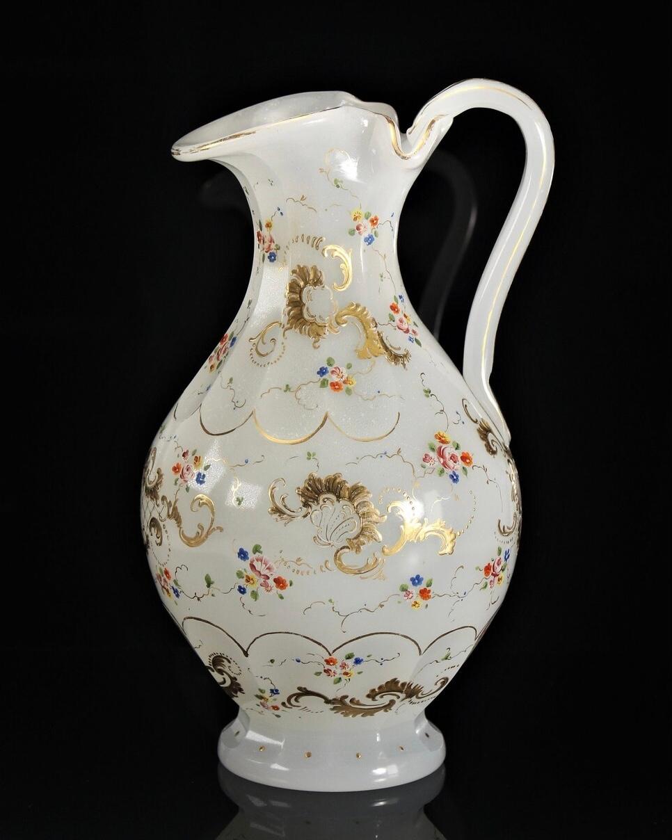 Beautiful hand painted Biedermeier era opaline pitcher by Moser

The beautiful translucent glass pitcher is enameled with scrolling gold fronds highlighted with lattice work of gold and arching lines of gold dots

Interspersed are trailing vines in