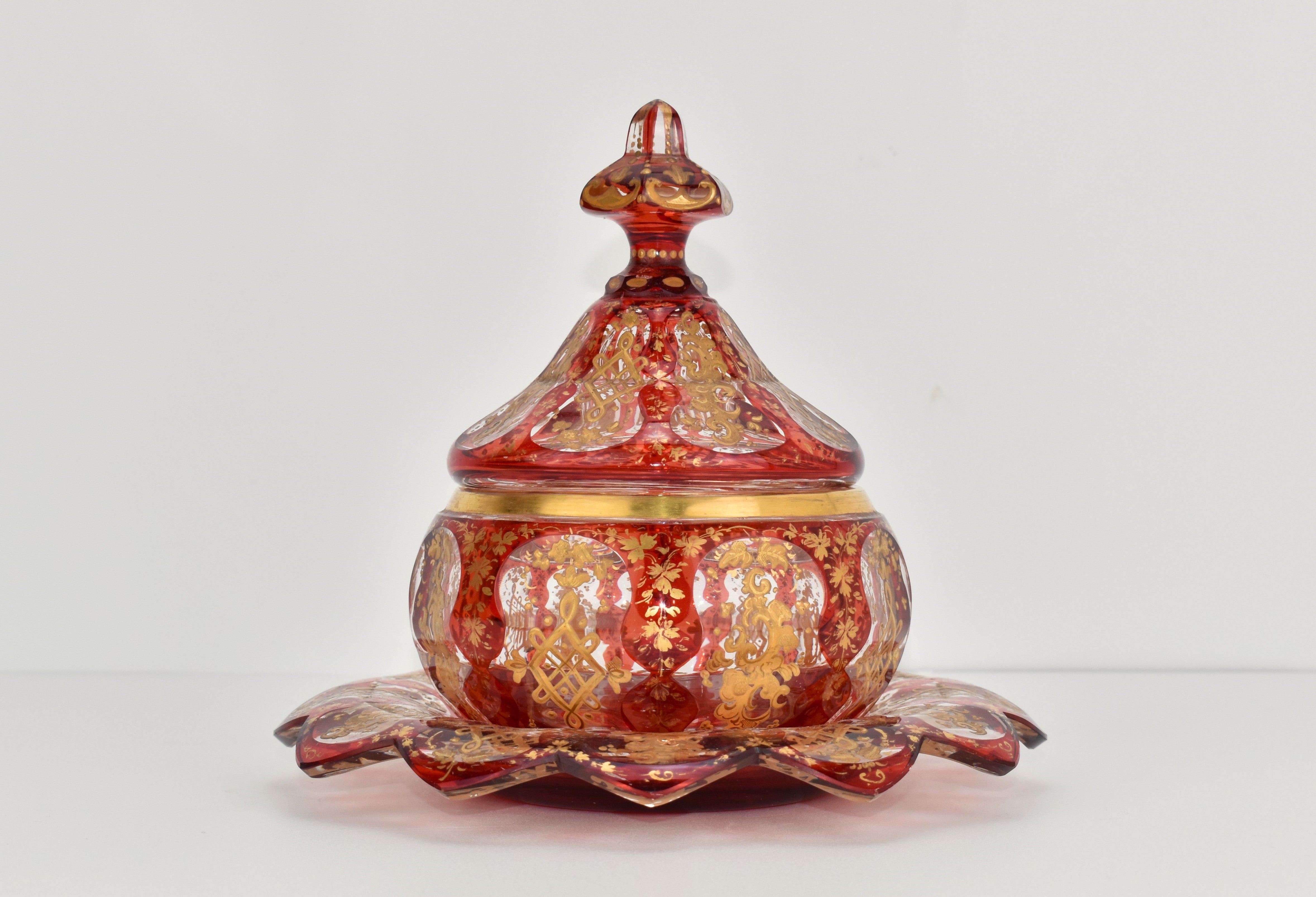 An exceptional museum quality sugar bowl with cover and saucer in ruby red overlay glass with enamel and gilding decoration

ruby cased cut clear-galss, richly cut and hand-painted all around with enamel and 24-carat matte and burnished gold, the