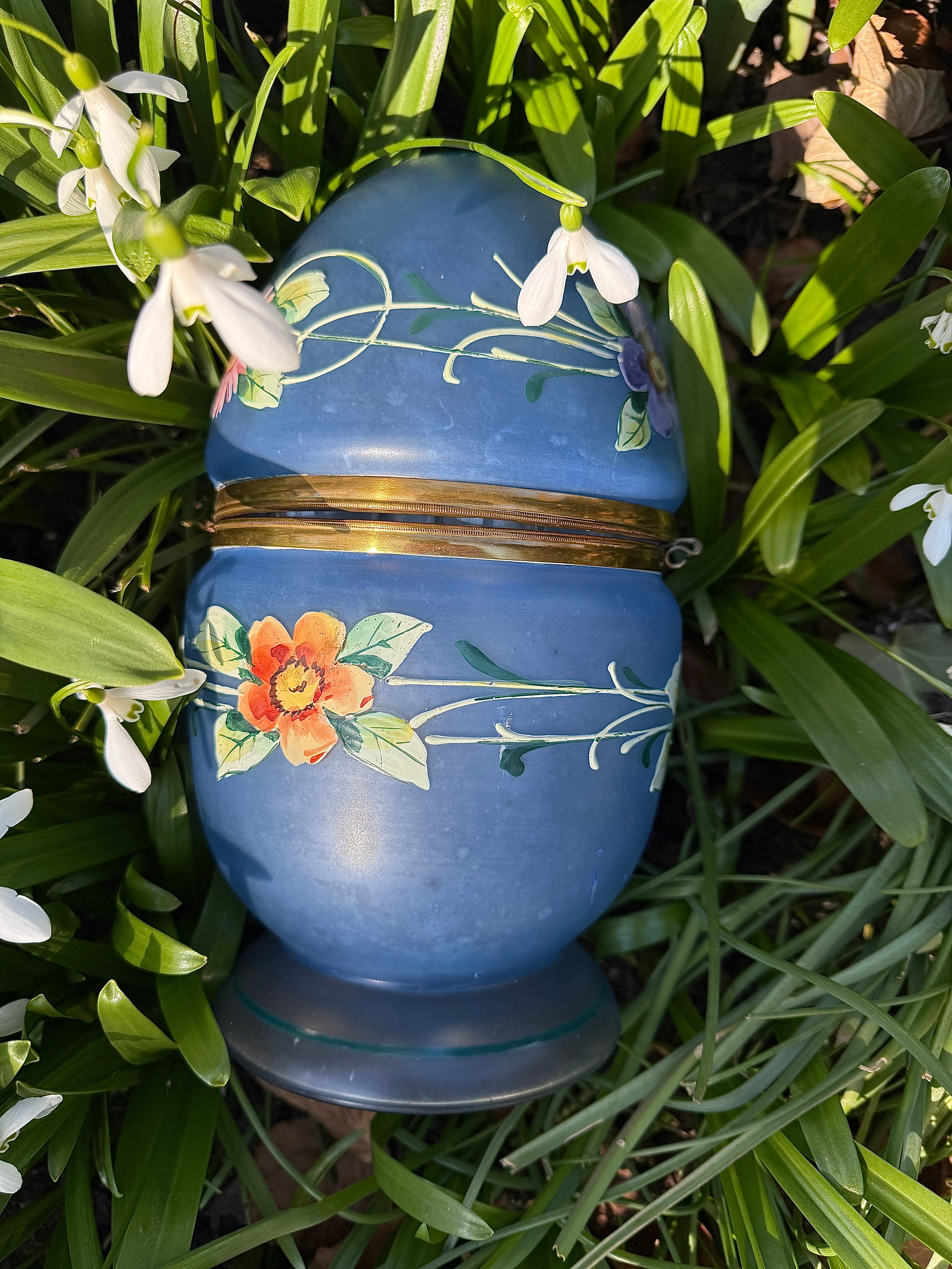 Questo fantastico uovo di vetro è stato dipinto a mano con fiori di diversi colori verso la fine del XIX secolo. L'uovo è stato progettato come una scatola con cerniera e supporti in ottone. L'uovo si apre per rivelare un decanter in vetro con sei