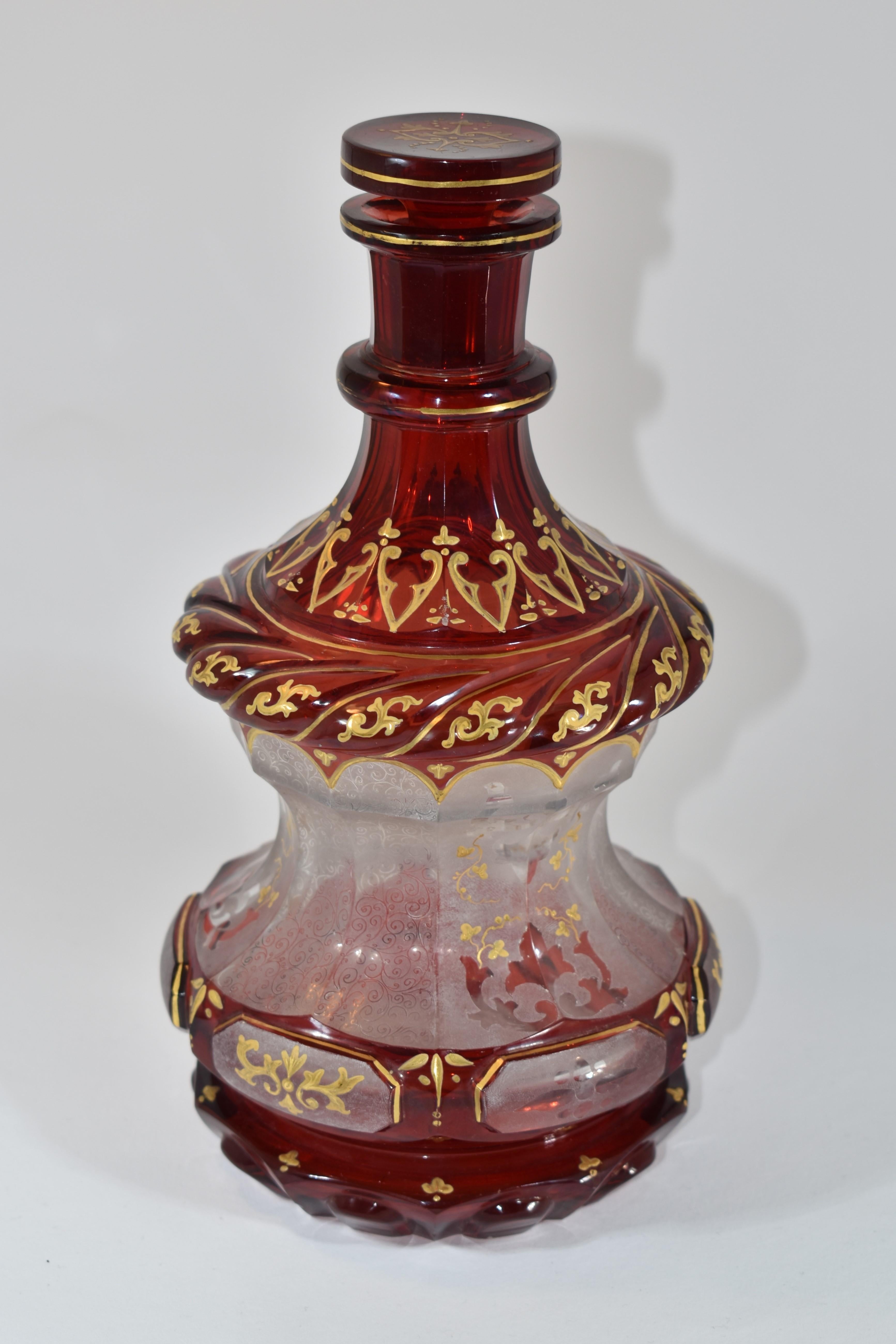 Böhmisches Glas, tief rubinrot geschliffene Glasflasche und Stopfen

verziert mit eindrucksvoller vergoldeter Emaille und feinem Malereidekor, der über und über mit Schnörkeln und geomertrischen Mustern verziert ist

ein Beispiel für die hohe
