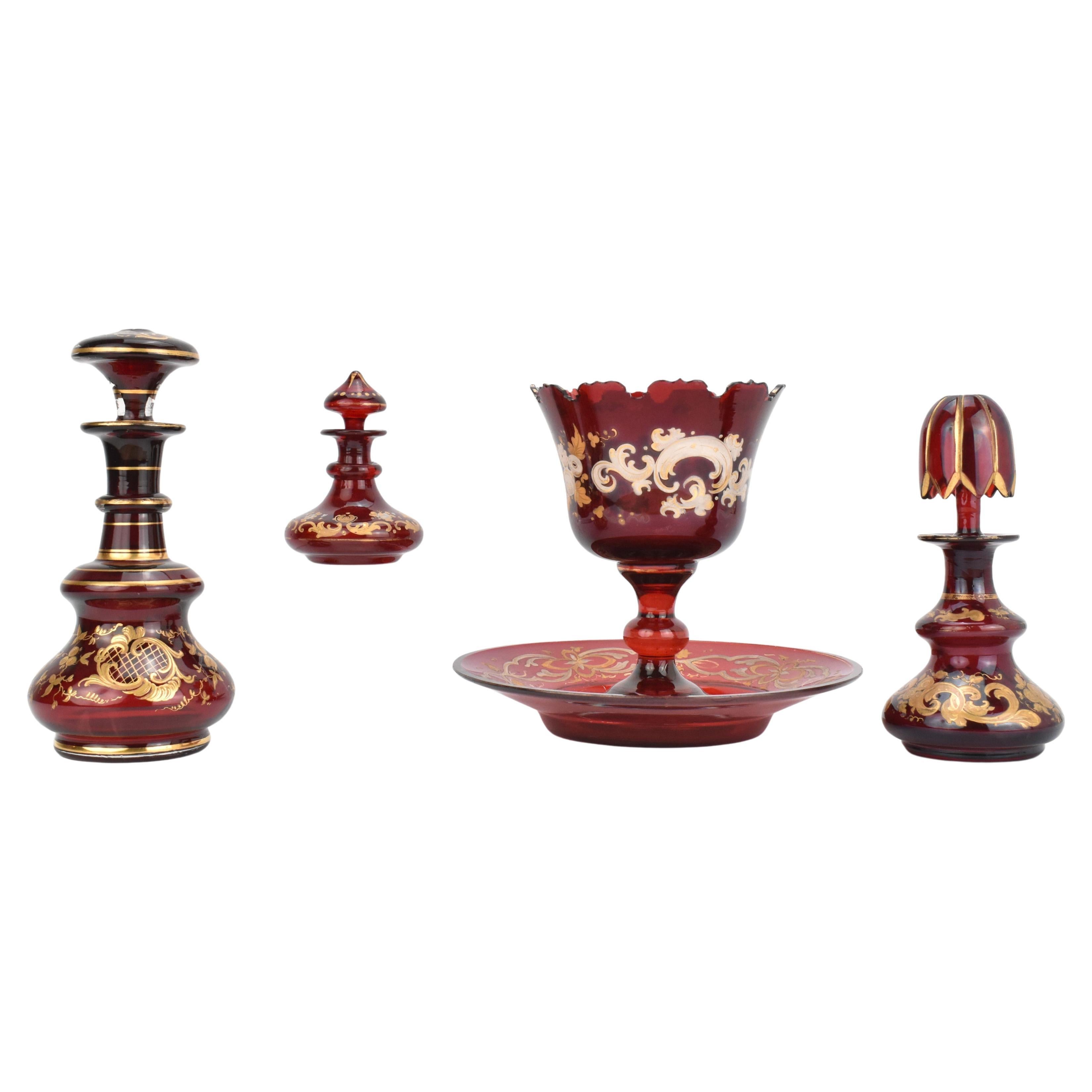 Collection'S di vetro antico di Boemia color rubino - Bottiglie di profumo, centrotavola e piattino, Bohemia, 1850

Questa elegante collezione di vetro antico rubino di Boemia comprende tre bottiglie di profumo con tappo e una ciotola da