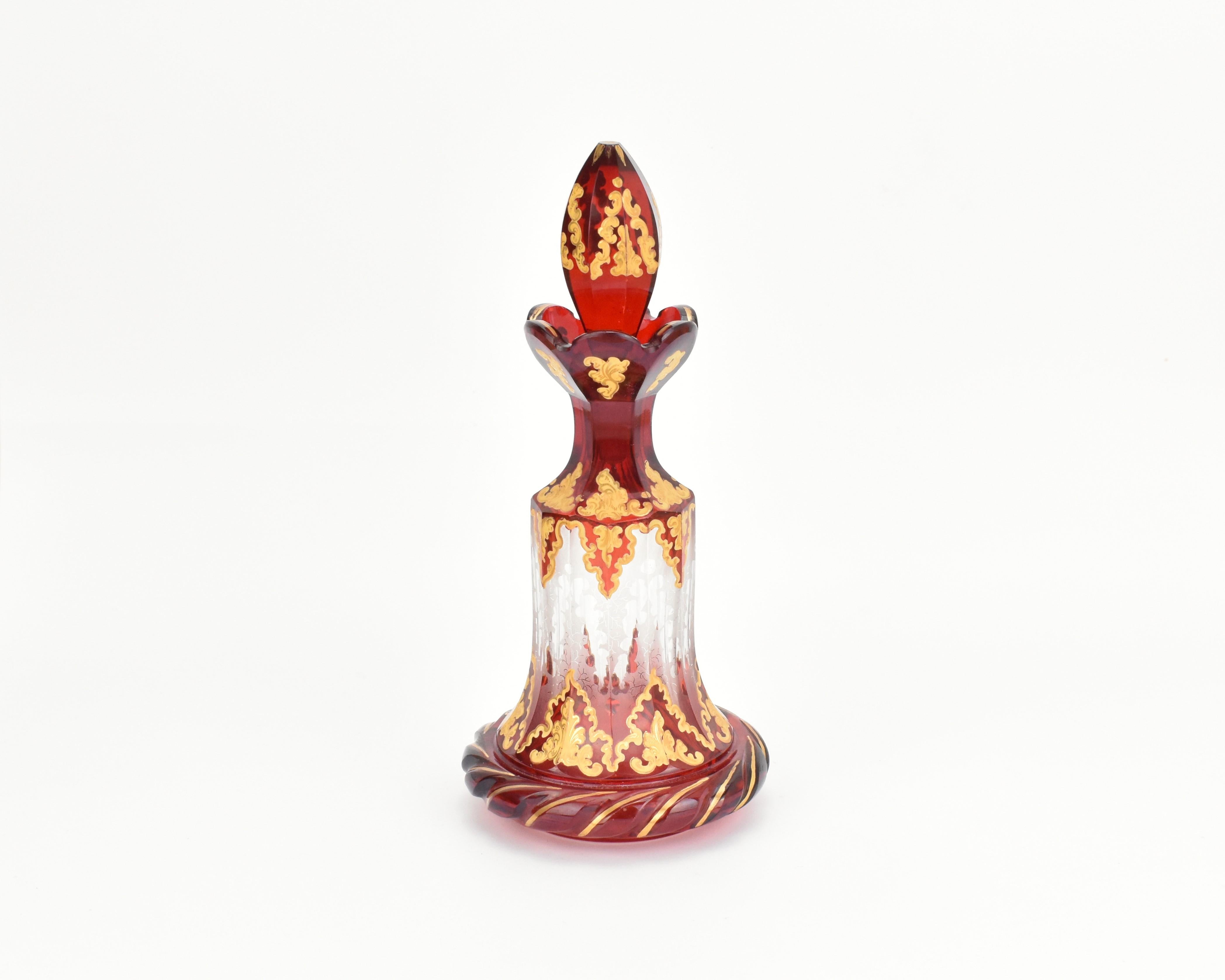 Questa eccezionale bottiglia di profumo in vetro tagliato rosso rubino del XIX secolo, completa di tappo abbinato, è un capolavoro di artigianato e design. Realizzato in vetro bicolore, la combinazione di rosso rubino e vetro trasparente crea un