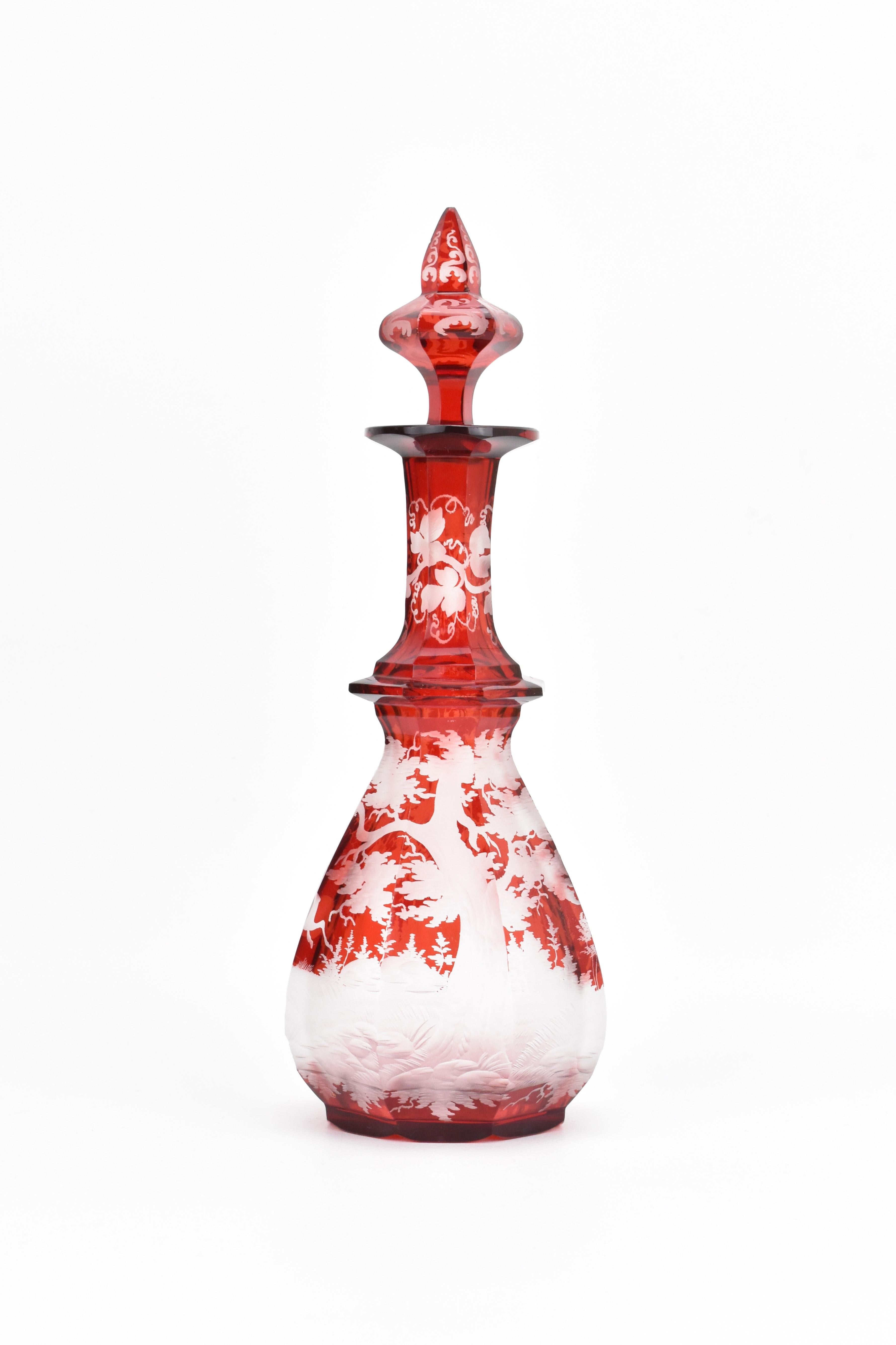 Ce rare flacon de parfum rouge rubis, fabriqué en verre taillé de Bohême de haute qualité, est un exemple remarquable de l'art du verre de Bohême du XIXe siècle. Le corps est découpé en plusieurs panneaux latéraux, présentant un anneau de cristal