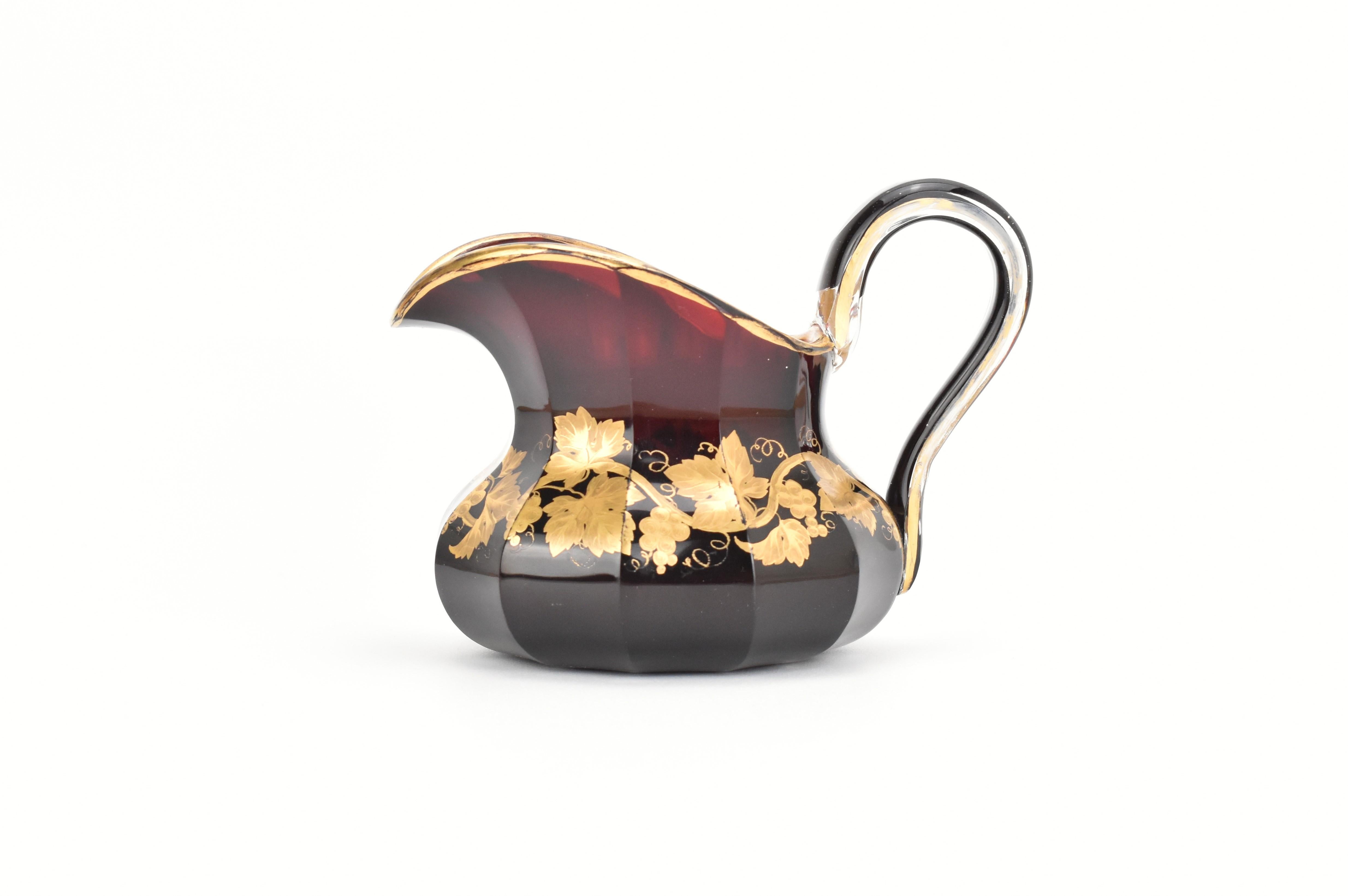 Questa antica brocca di vetro, realizzata in cristallo rosso rubino, esemplifica l'impressionante qualità, il colore e la sostanza per cui il vetro boemo del XIX secolo è famoso. La brocca è splendidamente dipinta a mano con intricate decorazioni in