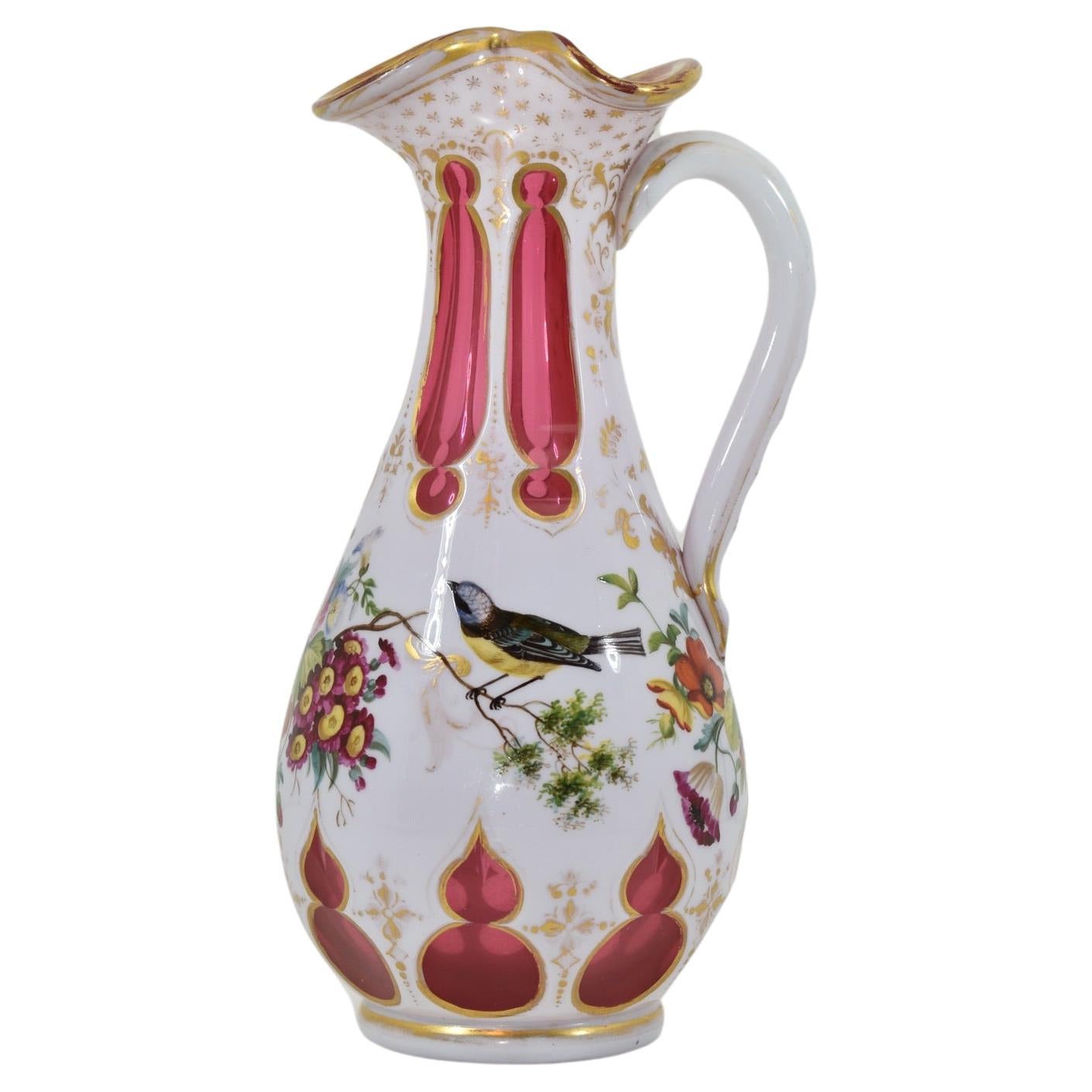 Rare overlaid glass jug.
Ruby glass with milky white opaline overlay.
Decorated with colourful enamel, featuring flowers birds snd gilding highlights. 
Bohemia, 19th century.