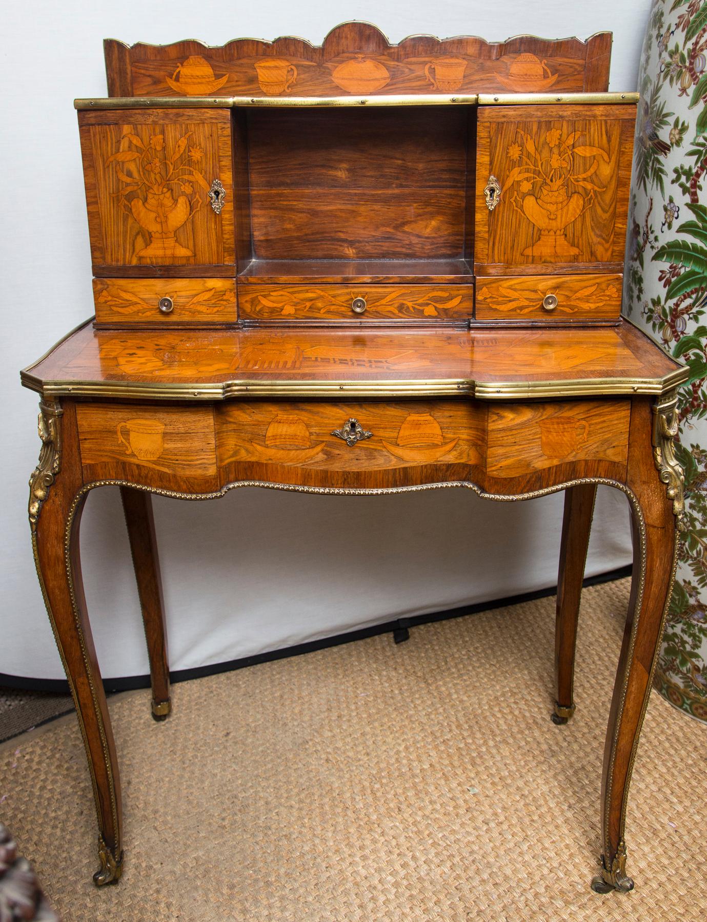 A beautiful bon heur de jour with inlays in the manner of Charles Topino. Made in two parts. 
Gilt bronze mounts. Secret buttons. within the small cabinet doors, to unlock the 2 side small drawers. Cabriole legs ending in original (?) casters. Of