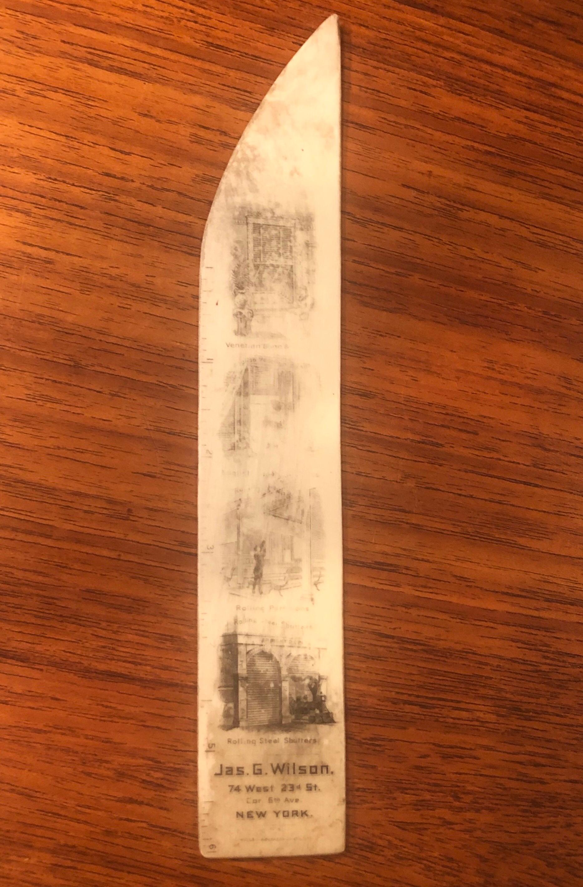 An antique book mark / ruler advertising Jas. G. Wilson's blinds and shutter shop at 74 West 23rd Street in New York City, circa 1910s. The graphics are a black transfer of various products the shop sells on a thin slice of bone with a ruler on one
