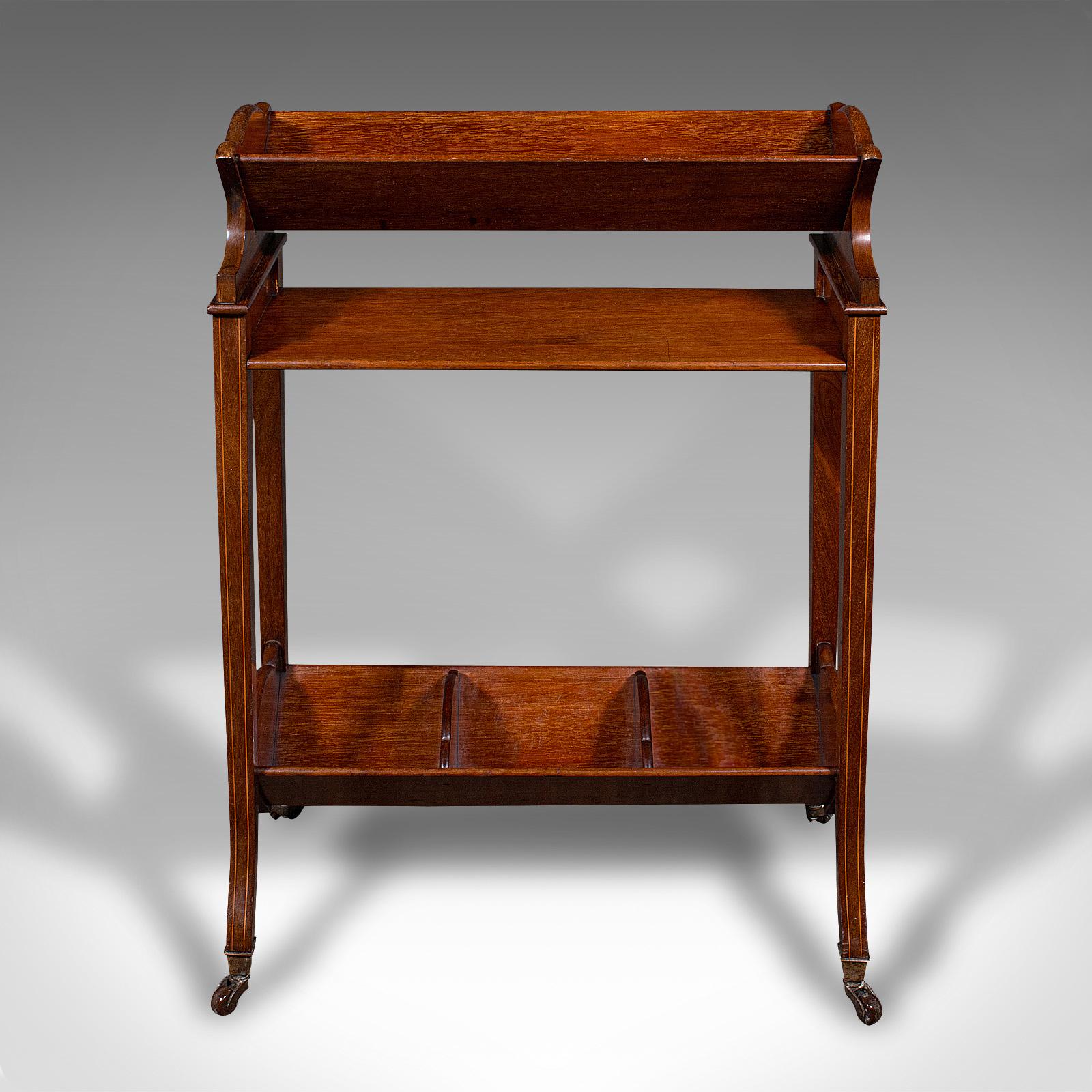 
This is an antique book trough stand. An English, walnut and boxwood lounge bookcase, dating to the Edwardian period, circa 1910.

Delightfully mobile stand, ideal for wheeling into a hotel lounge or home library
Displays a desirable aged patina