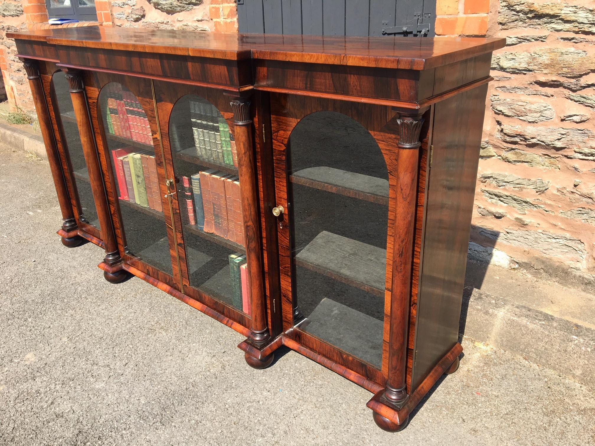 Good quality glazed four-door Rosewood Bookcase of break front design. English, and dated to circa 1830. 

This delightful bookcase has plenty of book space, being 77 inches long and with shelf depths of 11 ins and 13 inches. The colour is excellent