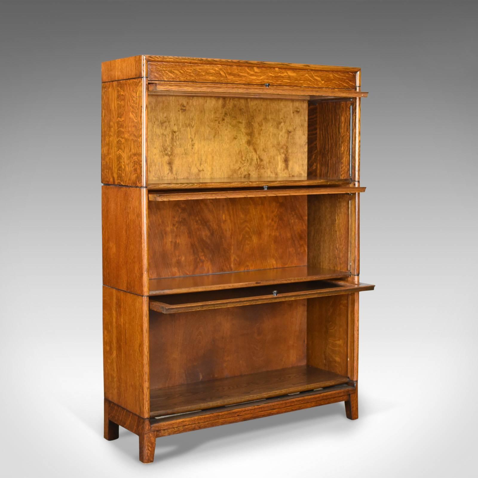 This is an antique bookcase, a three section, glazed, Globe Wernicke taste barrister's book shelf in English oak dating to the Edwardian era, circa 1910.

Oak with delicious honey tones in a wax polished finish
Grain interest throughout