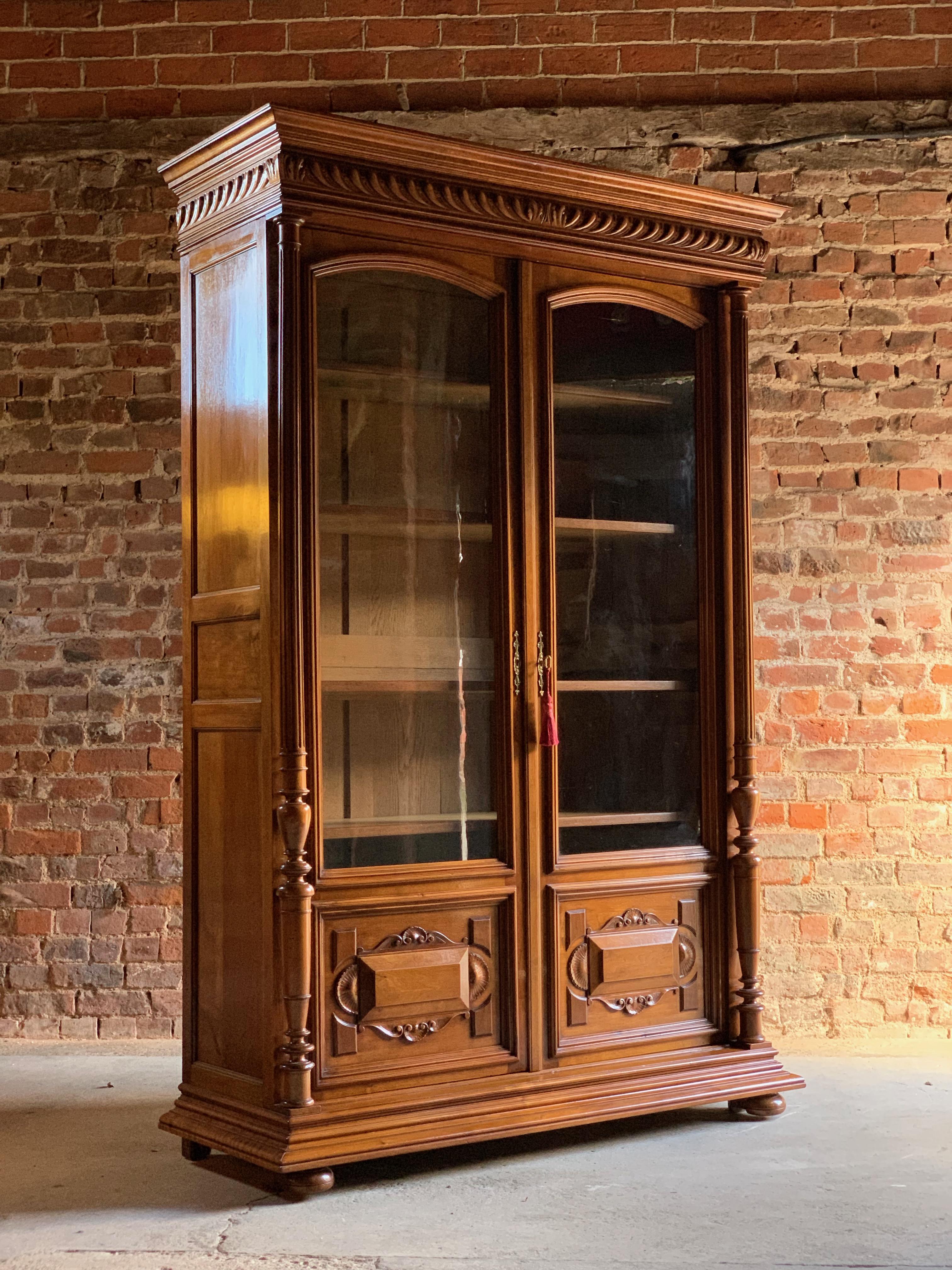 Fabulous antique 19th century French solid walnut bookcase vitrine, circa 1890 Number 3.

A fabulous tall and elegant 19th century French walnut two-door glazed bookcase vitrine circa 1890, the overhanging moulded carved cornice above two panelled