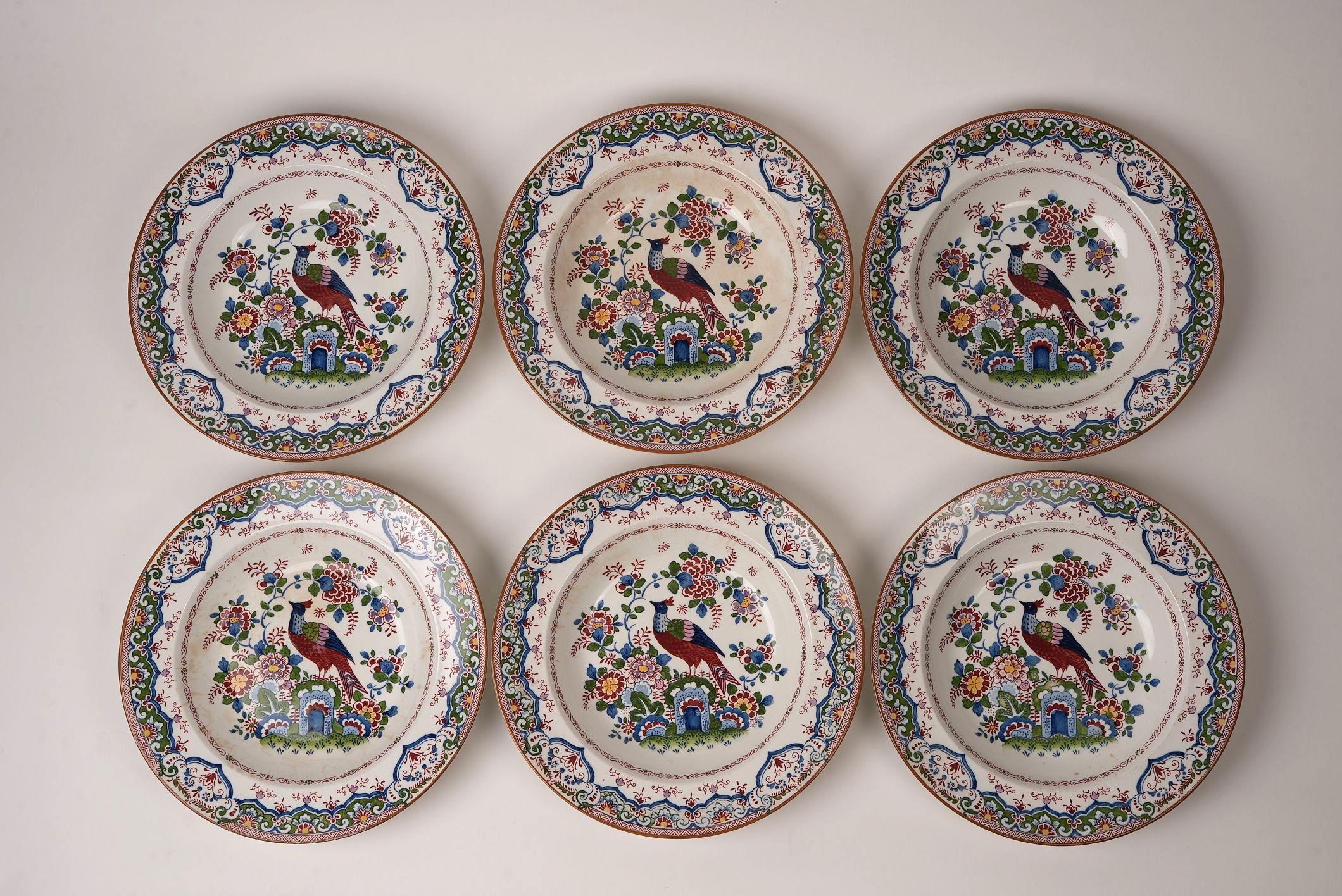 Dieses exquisite antike Tafelservice von Booth's zeigt das begehrte Old Dutch Peacock-Muster - ein detailreiches Chinoiserie-Design, das englische Handwerkskunst mit östlich inspirierten Motiven verbindet. Die zentrale Szene zeigt einen königlichen