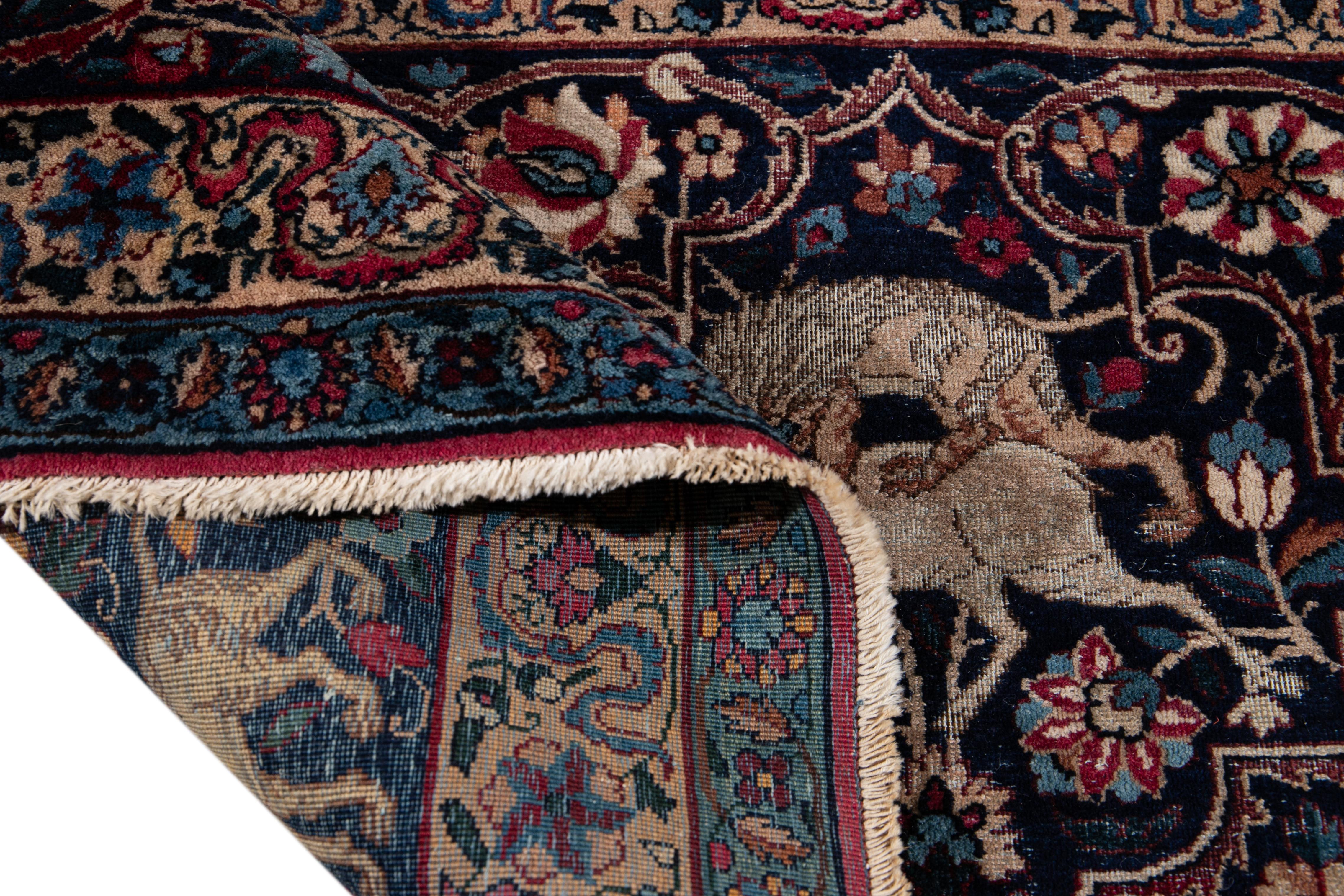 Beautiful antique Persian Kerman handmade oversize wool rug with a red field. This Kerman rug has a blue frame and accents of blue, beige, and brown in a gorgeous all-over botanical animal distressed design.

This rug measures 13' x 17'2