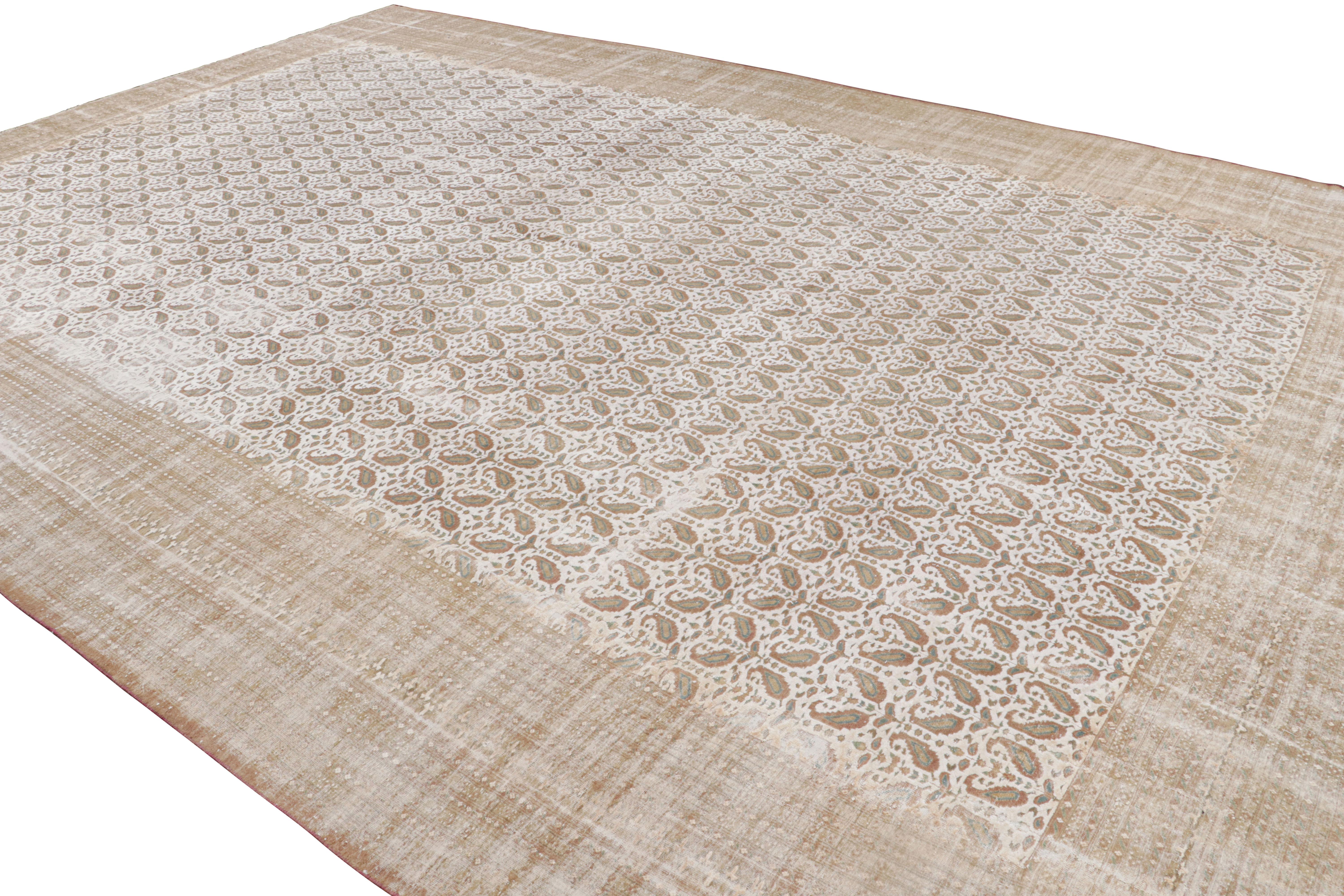 Hand knotted in Pakistan originating between 1880-1890, this antique wool rug enjoys one of the most uncommon variations of a Classic Boteh paisley pattern, sometimes referred to as the teardrop or flame pattern symbolizing elements of creation and