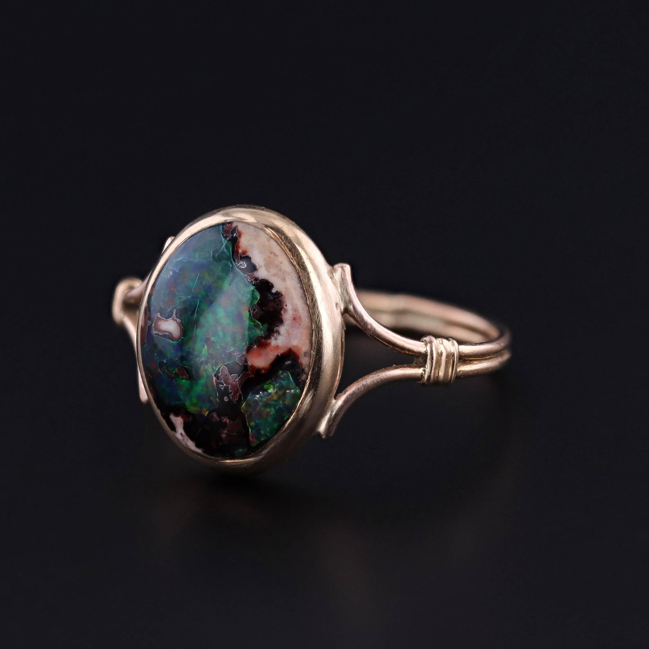 This ring features a boulder opal set in an 18k gold mounting. It was created from an antique stickpin head and an antique band, dating to 1890.

The face of the ring measures 0.5 inches by 0.4 inches wide, and it is in great condition.  The ring is