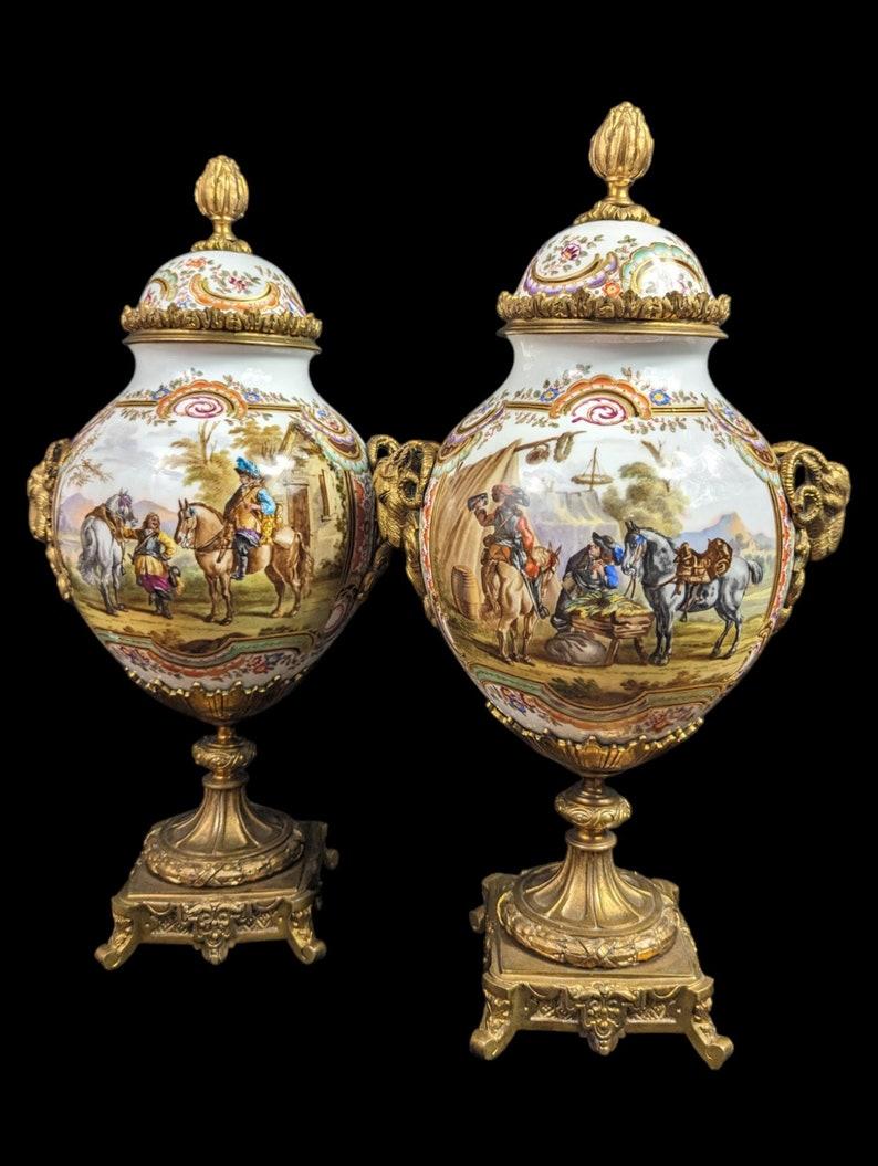 Elevate your decor with this magnificent pair of antique Bourdois Bloch Paris urns, each featuring striking war scenery and adorned with exquisite bronze ram head handles. These urns embody the grandeur and craftsmanship of 19th-century French