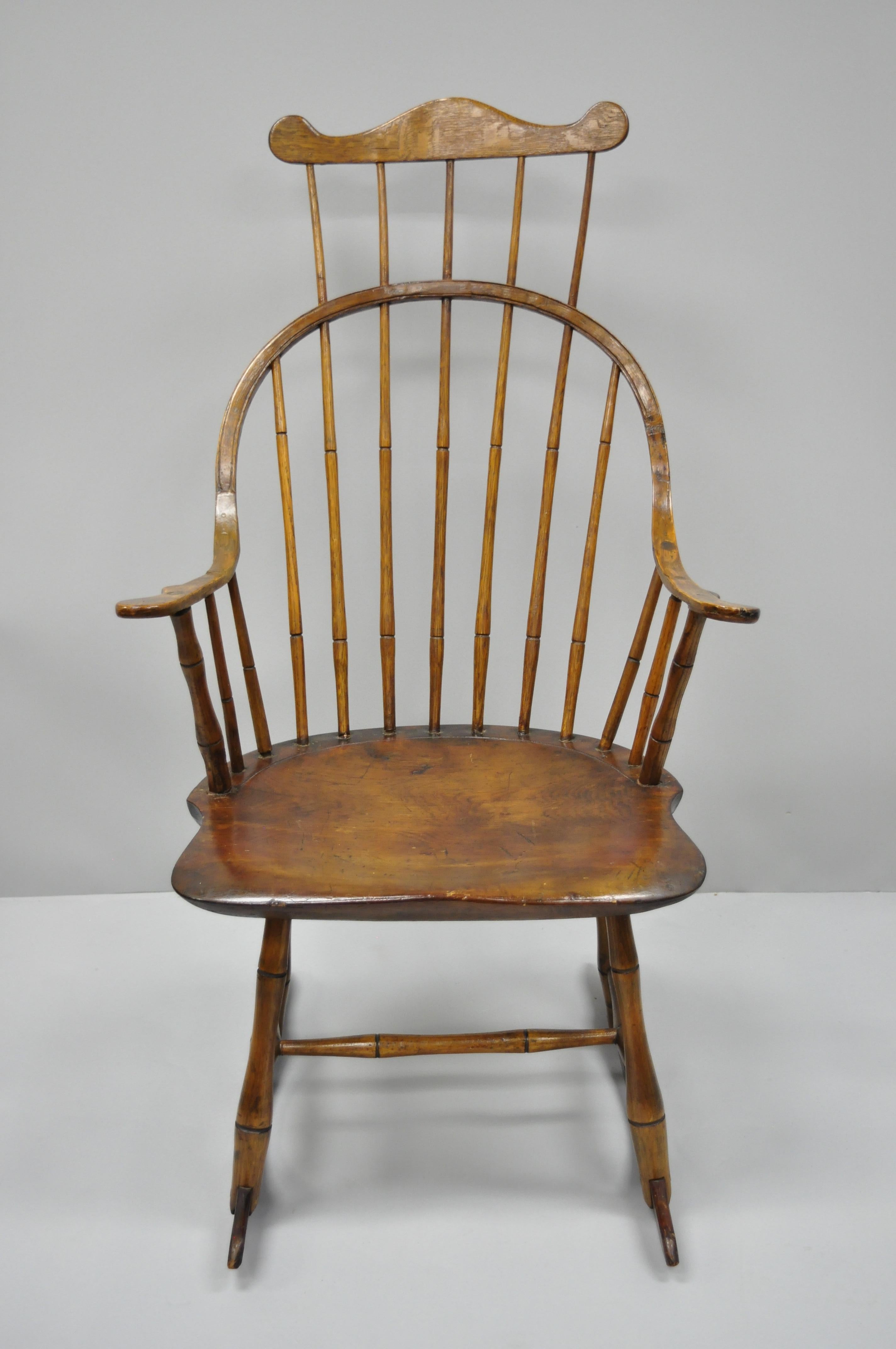 Antique handmade Colonial bow back Windsor oak and pine wood rocking chair. Item features handmade solid wood construction, beautiful wood grain, quality American craftsmanship, desirable older repairs/ metal brace which add wonderful character,