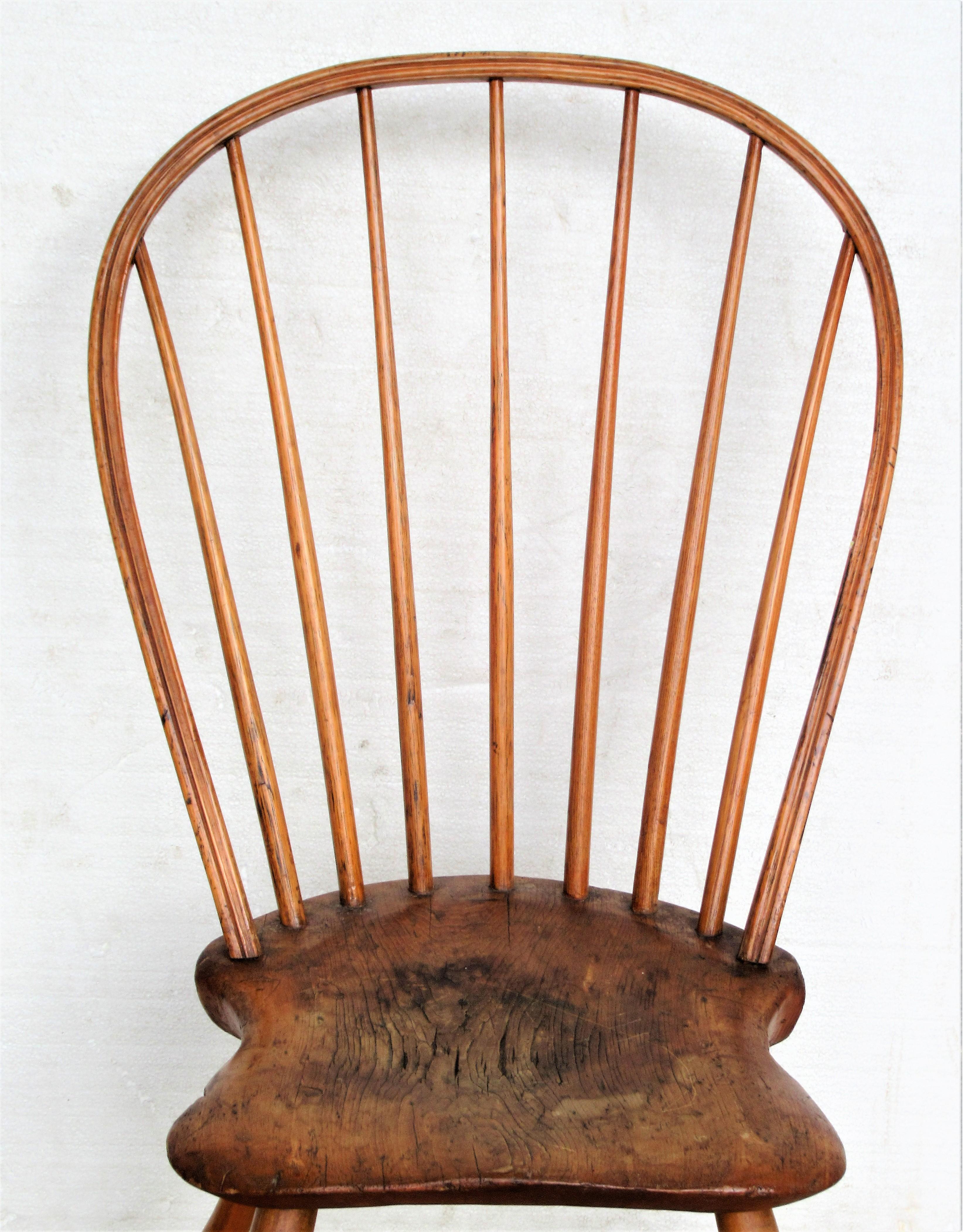 18th century bow back Windsor chair with bamboo turnings and a continuous bow like steam bent back crest that is mortised into the back of the saddle seat. Overall beautifully aged original honey color to wood with areas of darkening wear to seat