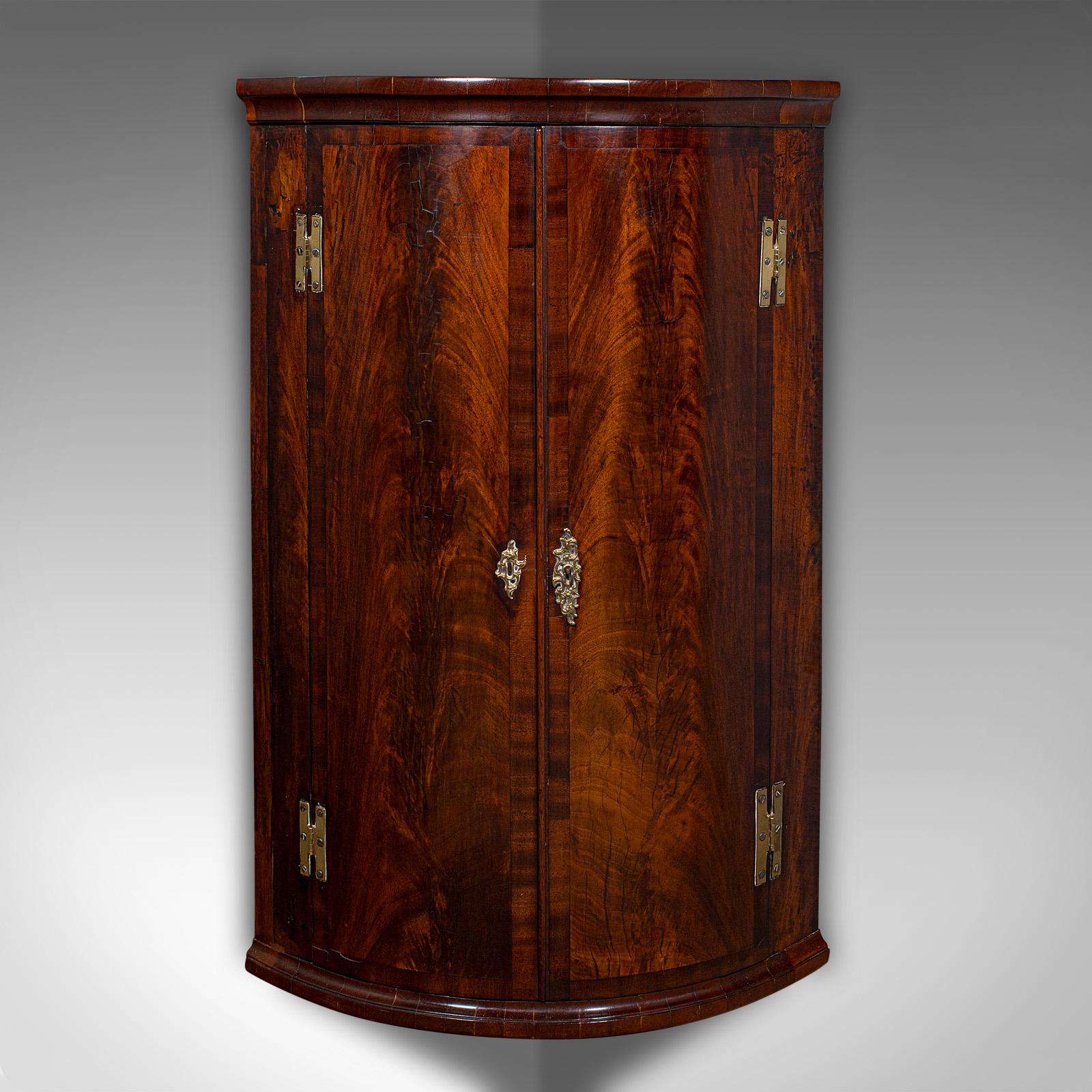 
Dies ist ein antiker Eckschrank mit Bogenfront. Ein englischer Wandschrank aus geflammtem Mahagoni und Eichenholz aus der mittleren georgianischen Periode, um 1780.

Attraktives mittelgeorgianisches Beispiel mit auffälliger Farbe
Mit