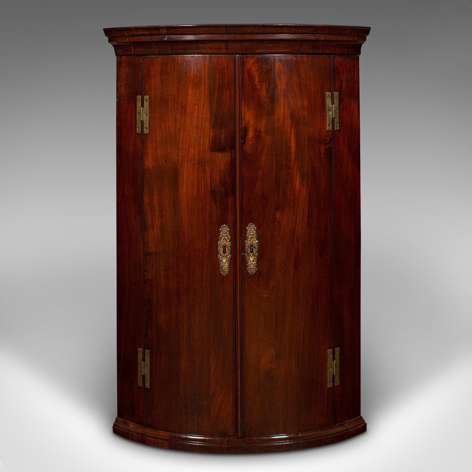 This is an antique bow front corner cabinet. An English, mahogany and oak wall cupboard, dating to the Georgian period, circa 1770.

Superb craftsmanship and figuring to this fine Georgian example
Displays a desirable aged patina and in good